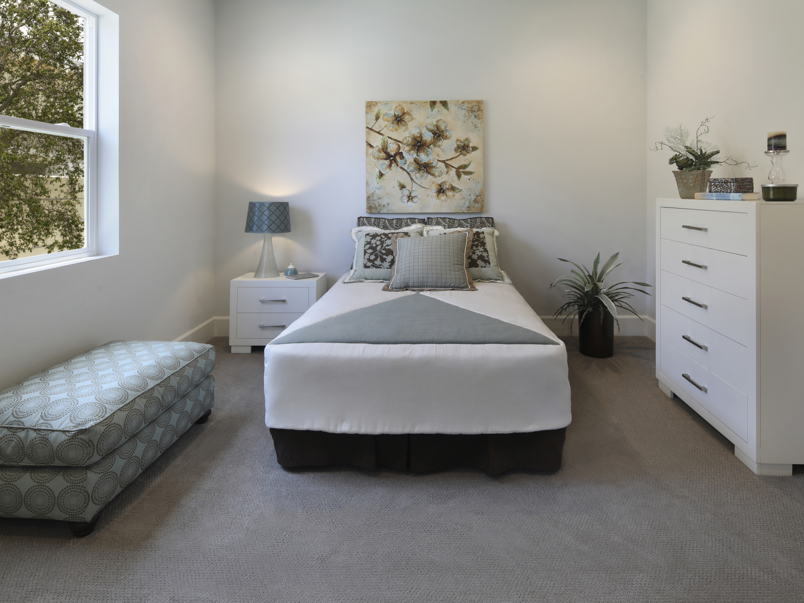 Спальная комната с кроватью и мягкой лежанкой у окна 