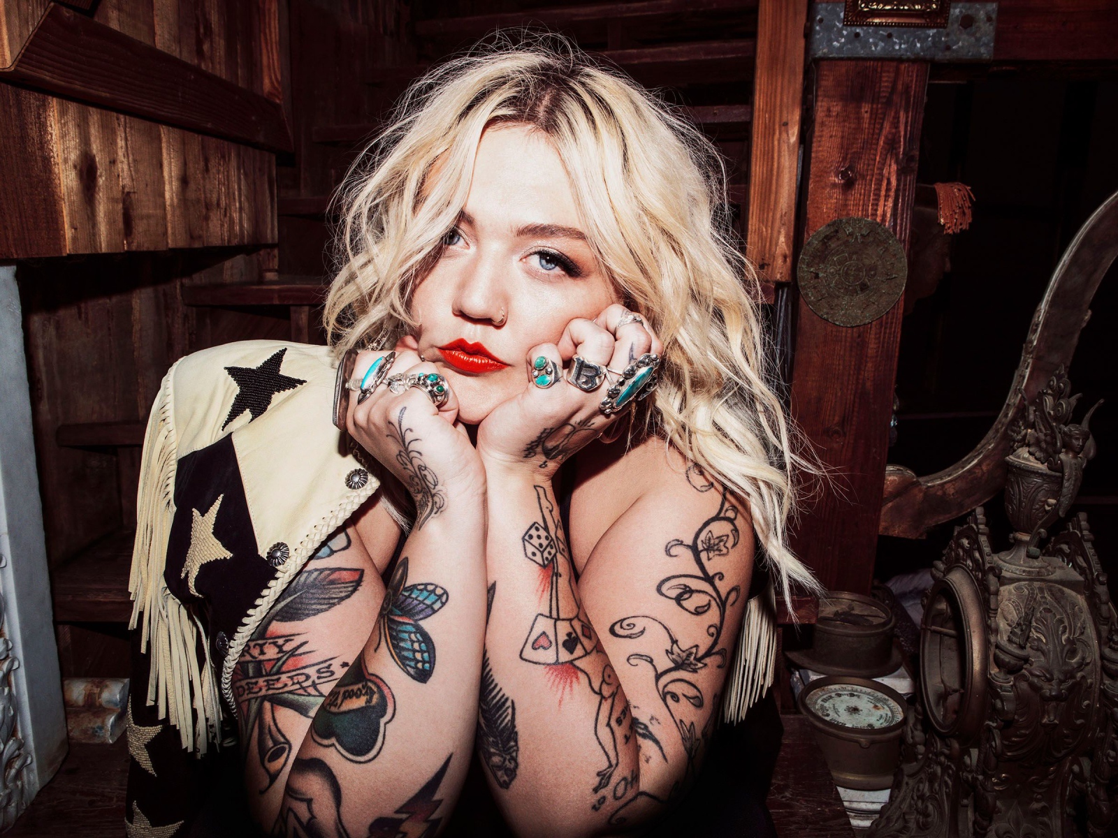 Голубоглазая блондинка с татуировками на руках