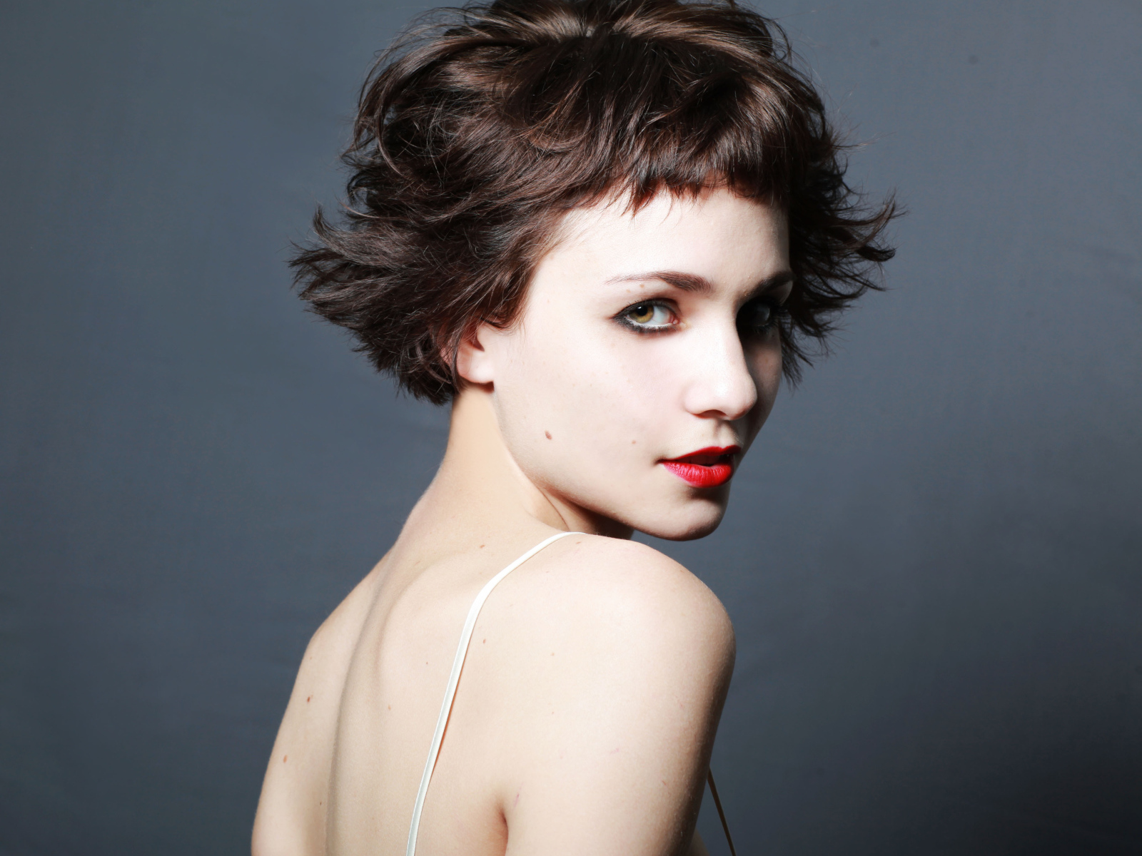 Яркая девушка с короткой стрижкой, актриса Таппенс Мидлтон на сером фоне