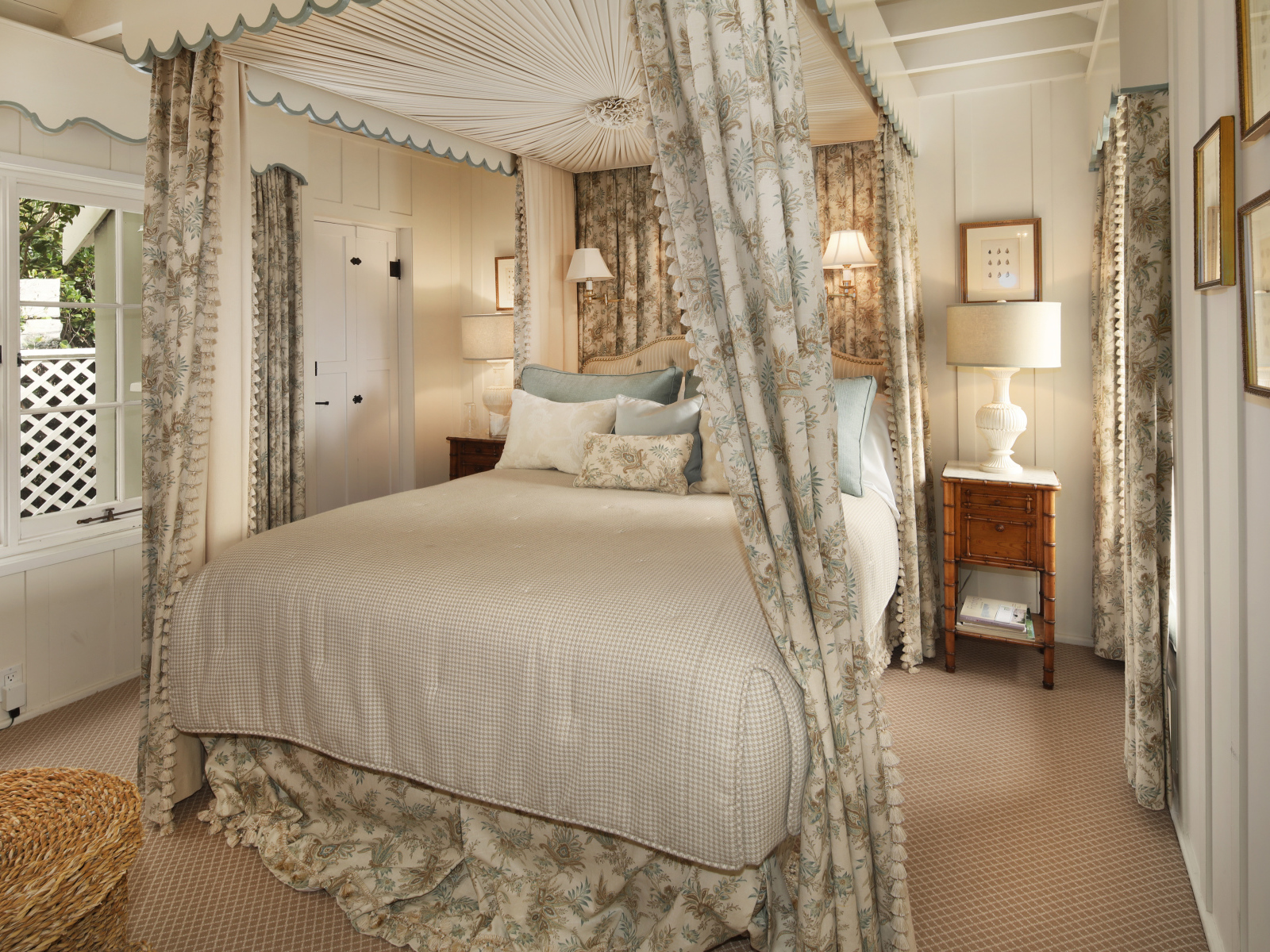 Высокая кровать с занавесками в спальной комнате в пастельных тонах 