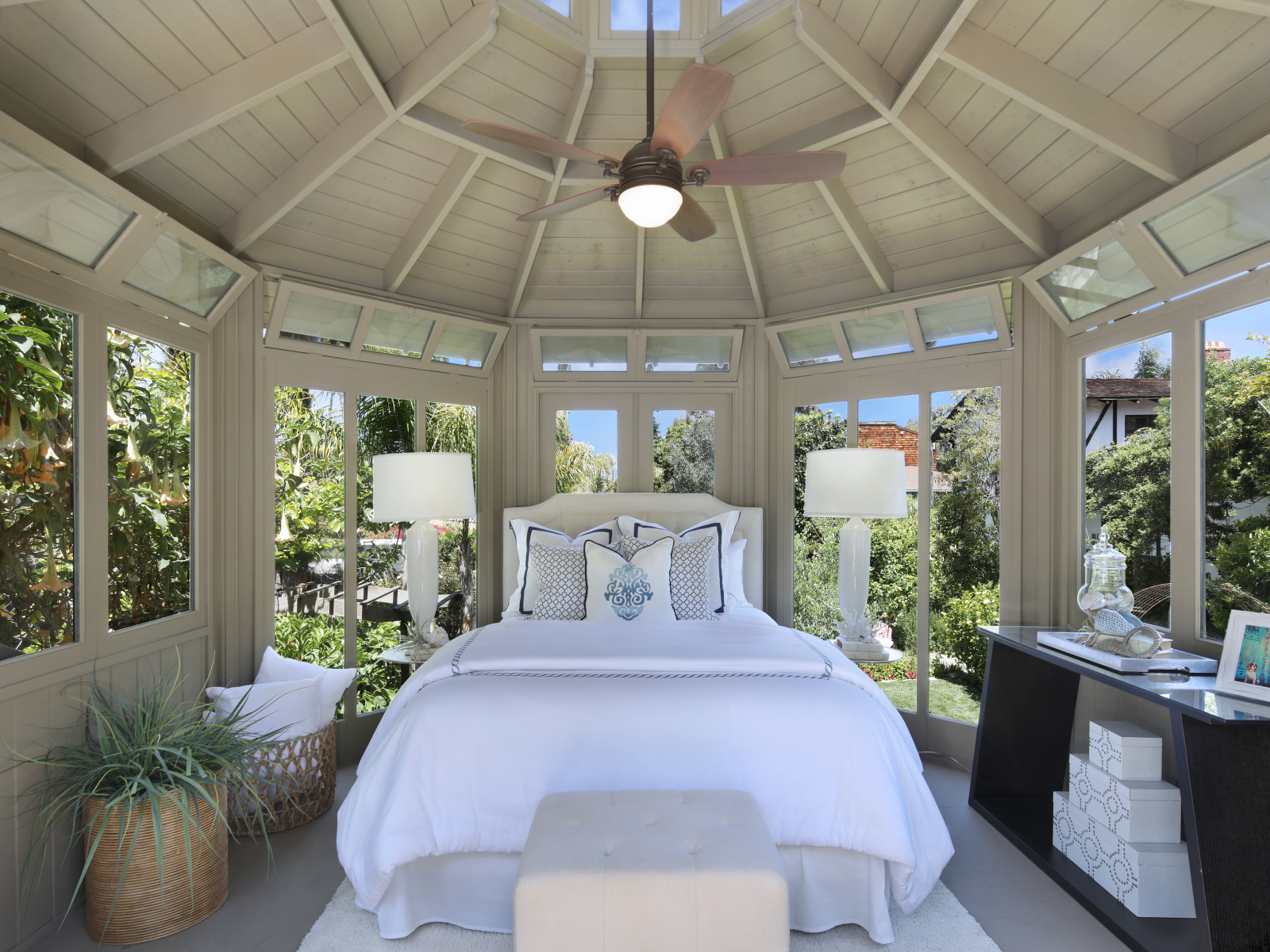 Большая спальная комната с окнами и белой кроватью 