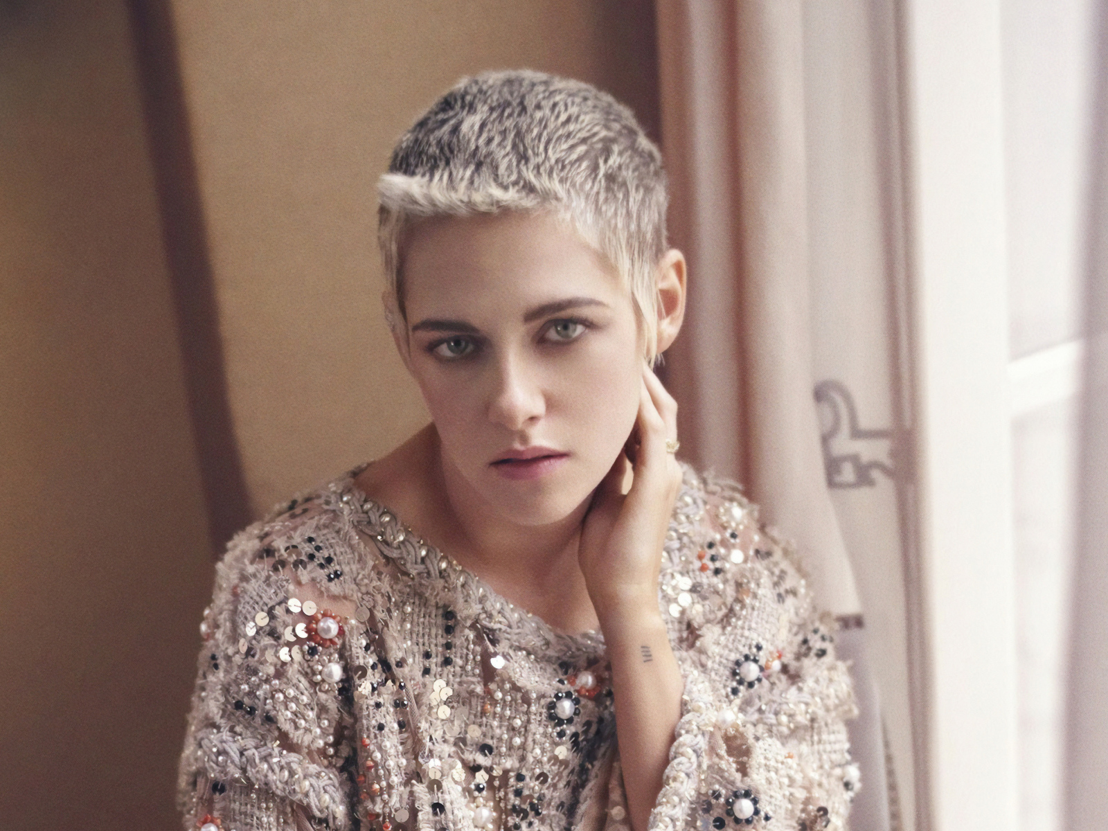 Актриса Кристен Стюарт с короткой стрижкой у окна