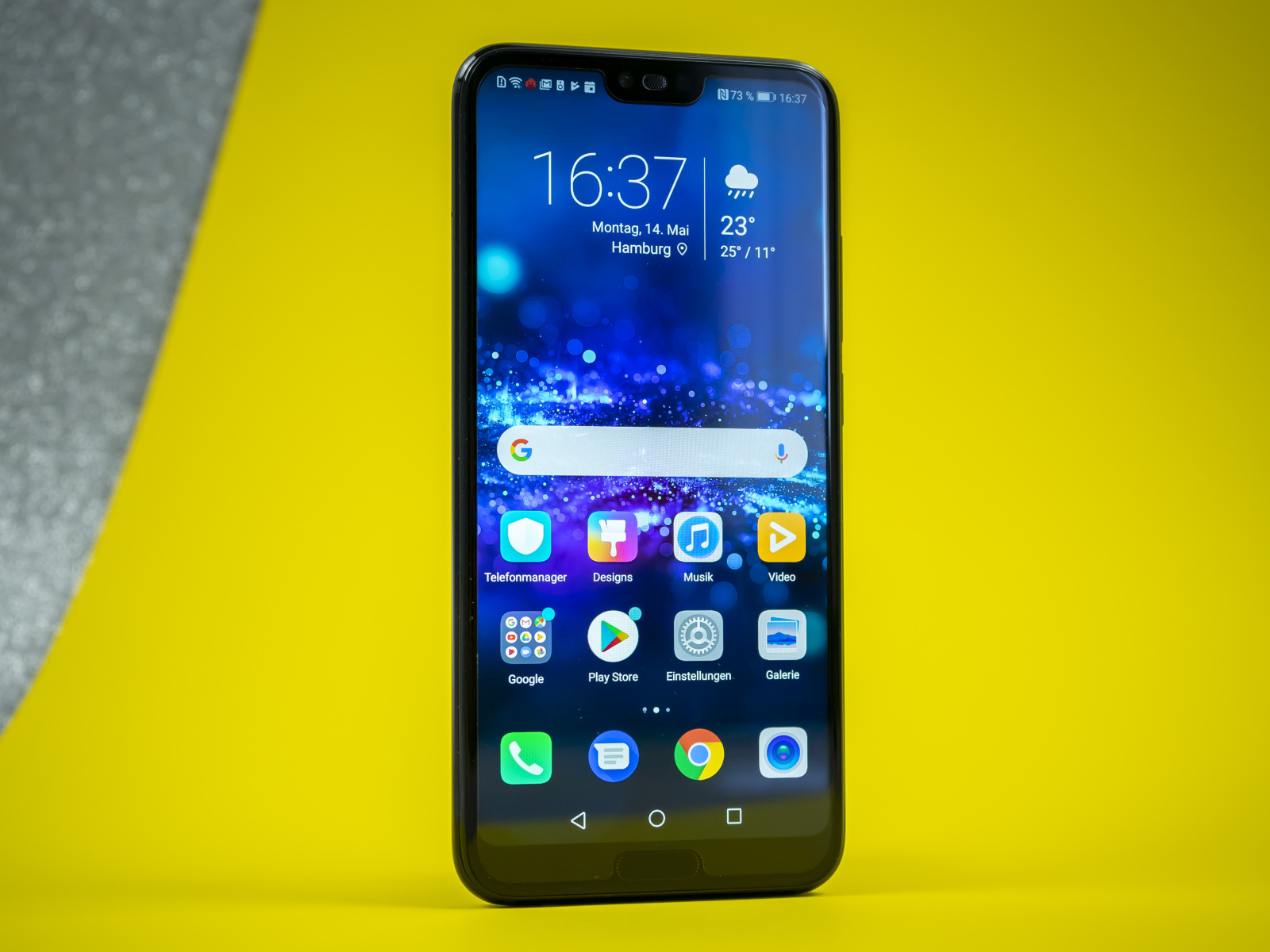 Тонкий смартфон Honor 10 на желтом фоне