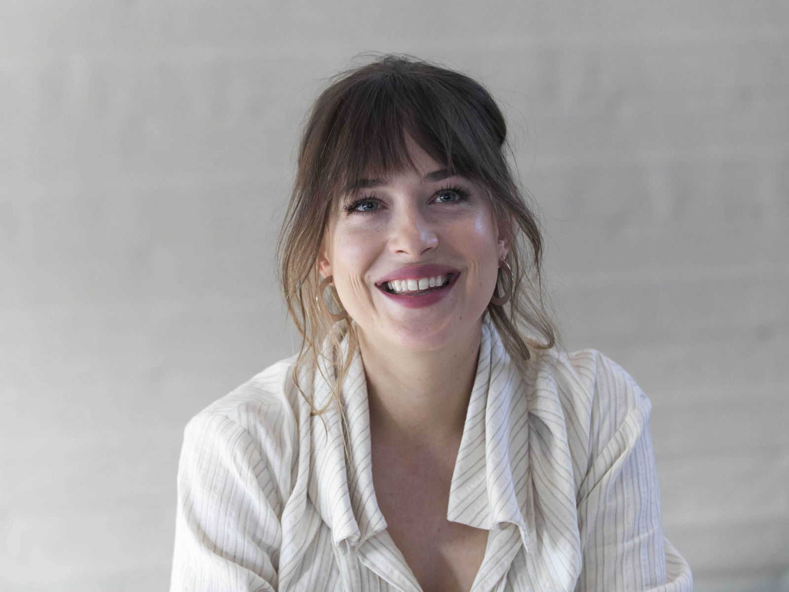 Улыбающаяся девушка актриса Дакота Джонсон в рубашке