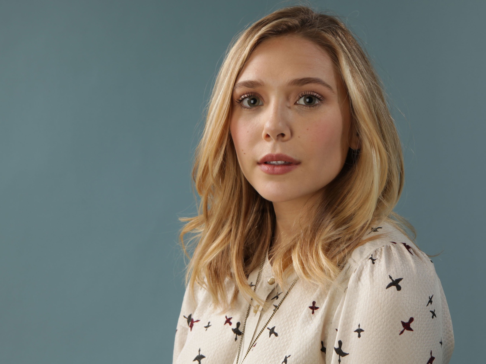 Нежная девушка, актриса Элизабет Олсен на сером фоне