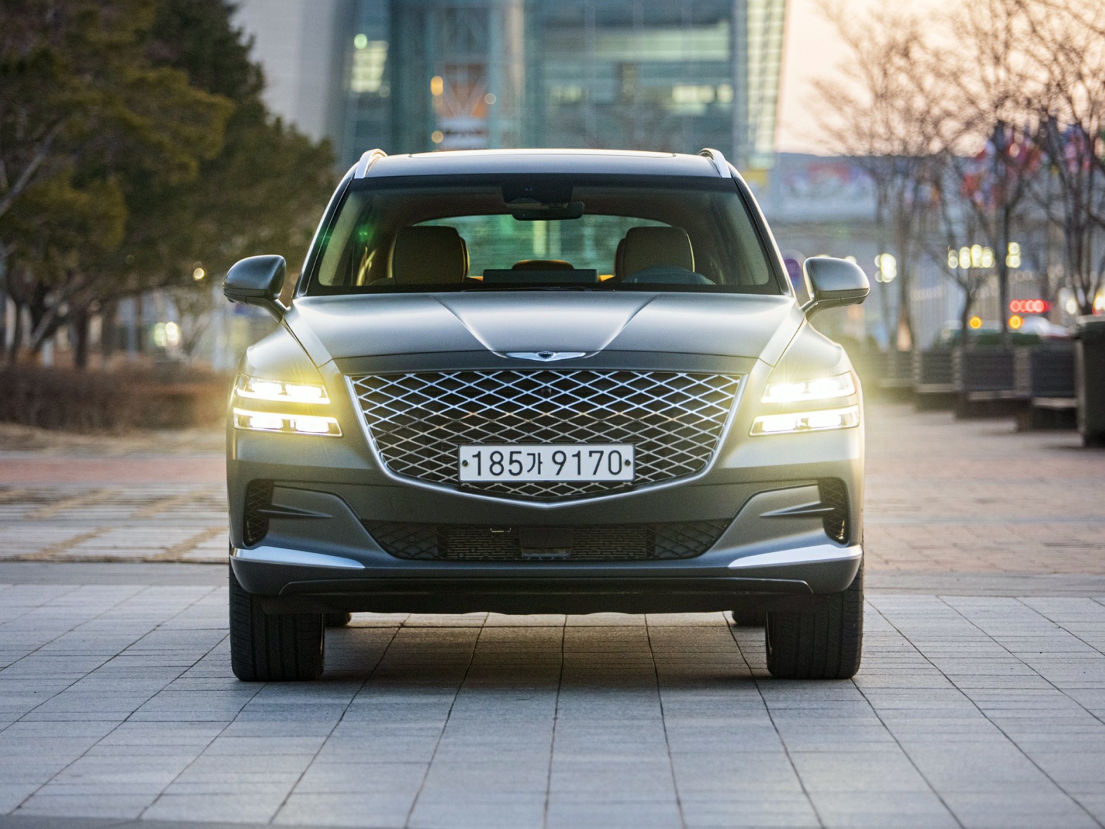 Автомобиль Genesis GV80,  2020 года с включенными фарами