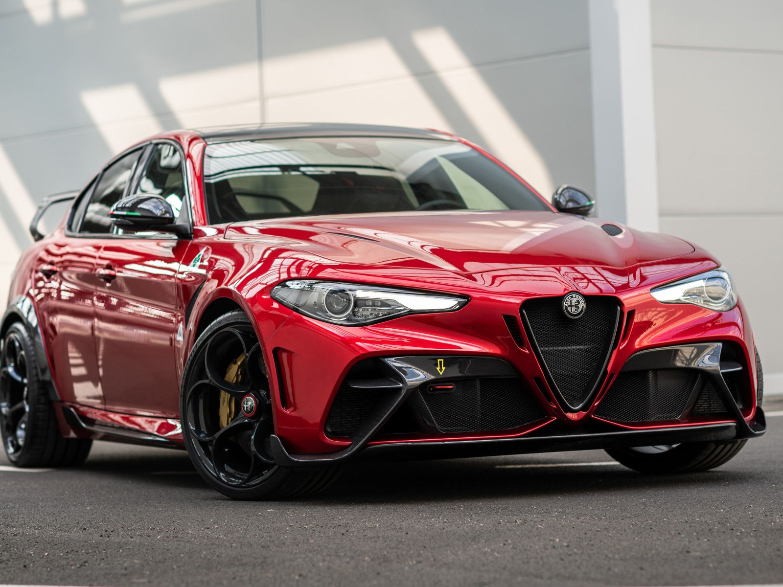 Красный автомобиль Alfa Romeo Giulia GTAm 2020 года у гаража