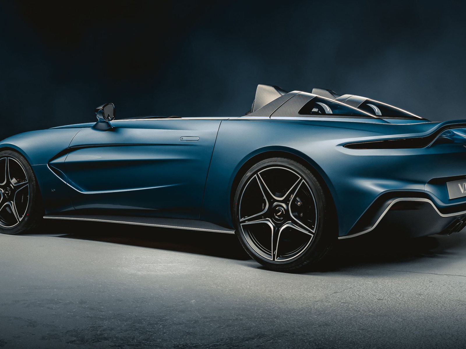 Синий автомобиль Aston Martin V12 Speedster 2020 года вид сбоку 