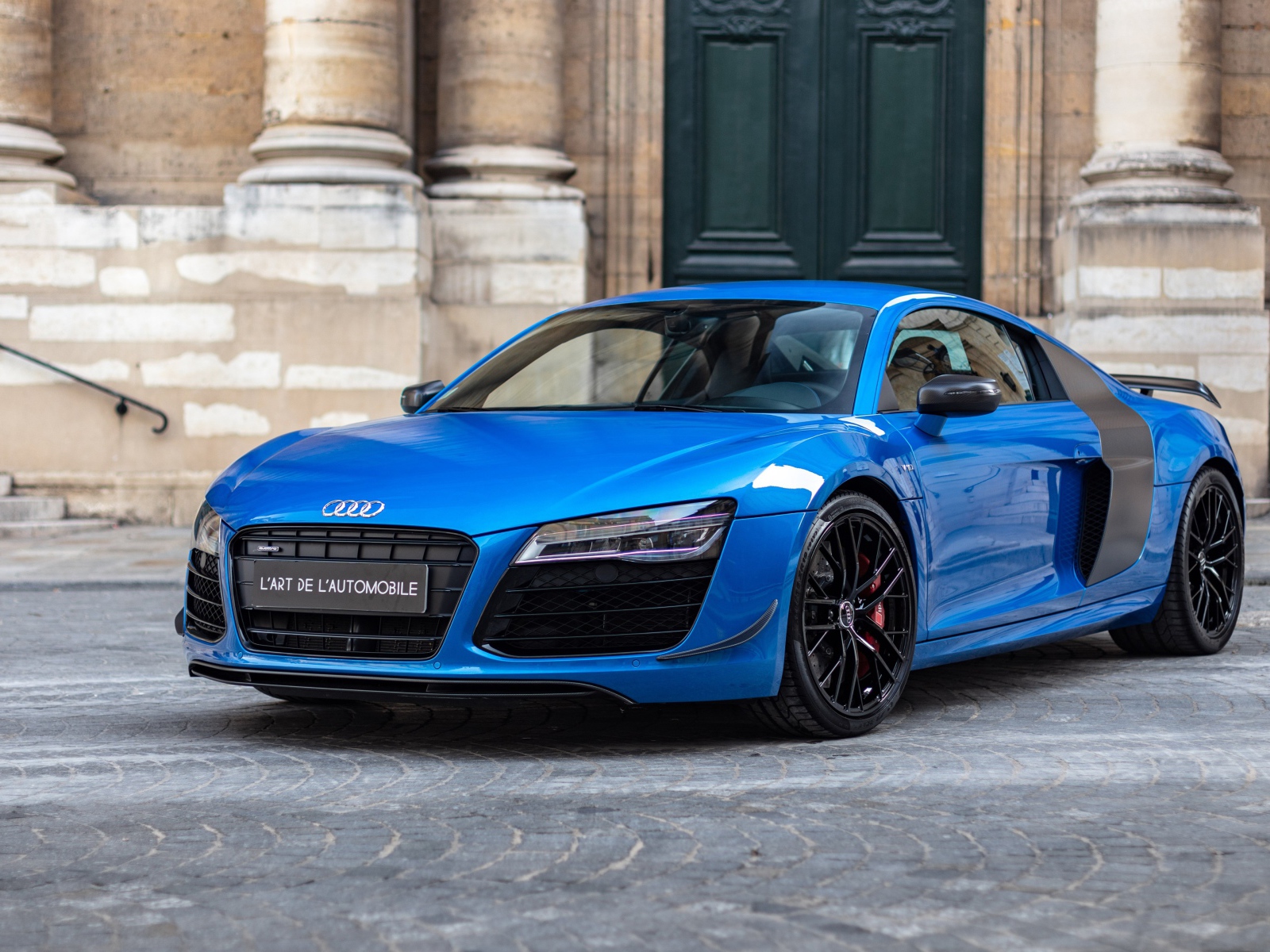 Синий автомобиль Audi R8 LMX у старого здания