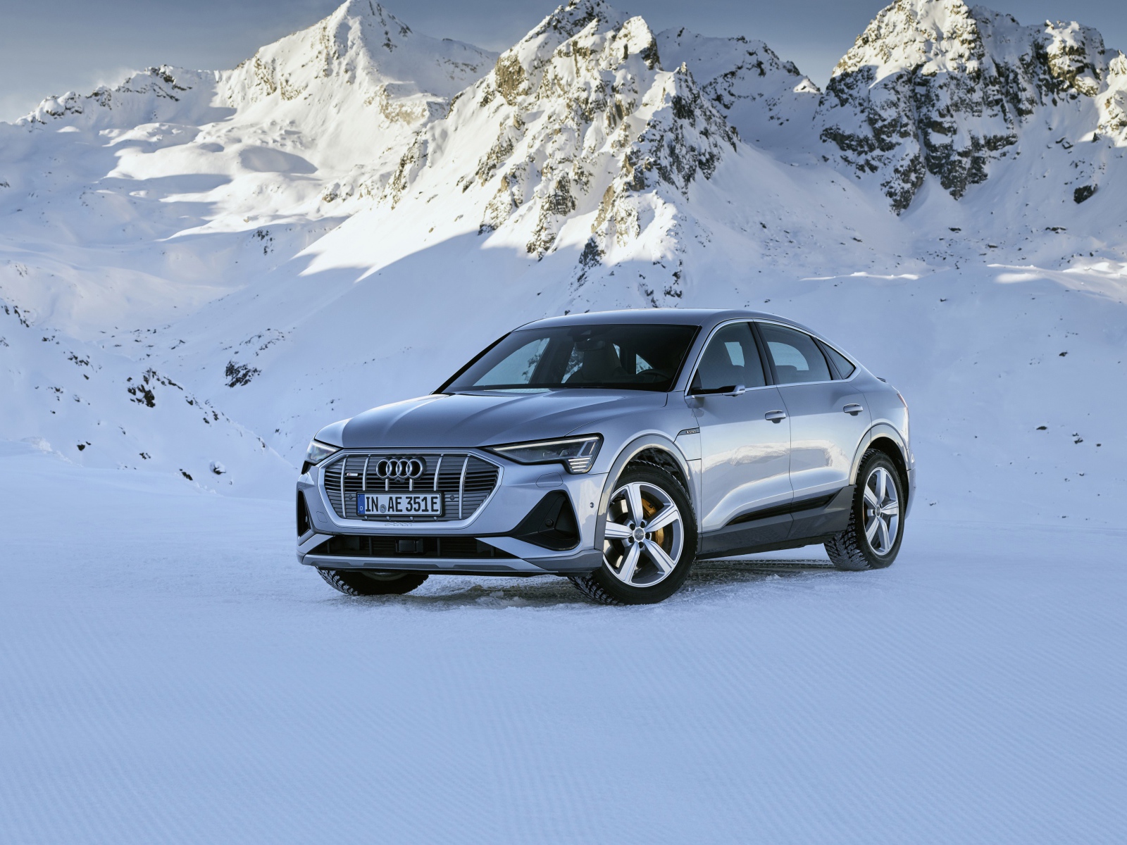 Автомобиль Audi E-Tron 55 Quattro Sportback S Line, 2020 года на фоне заснеженных гор 
