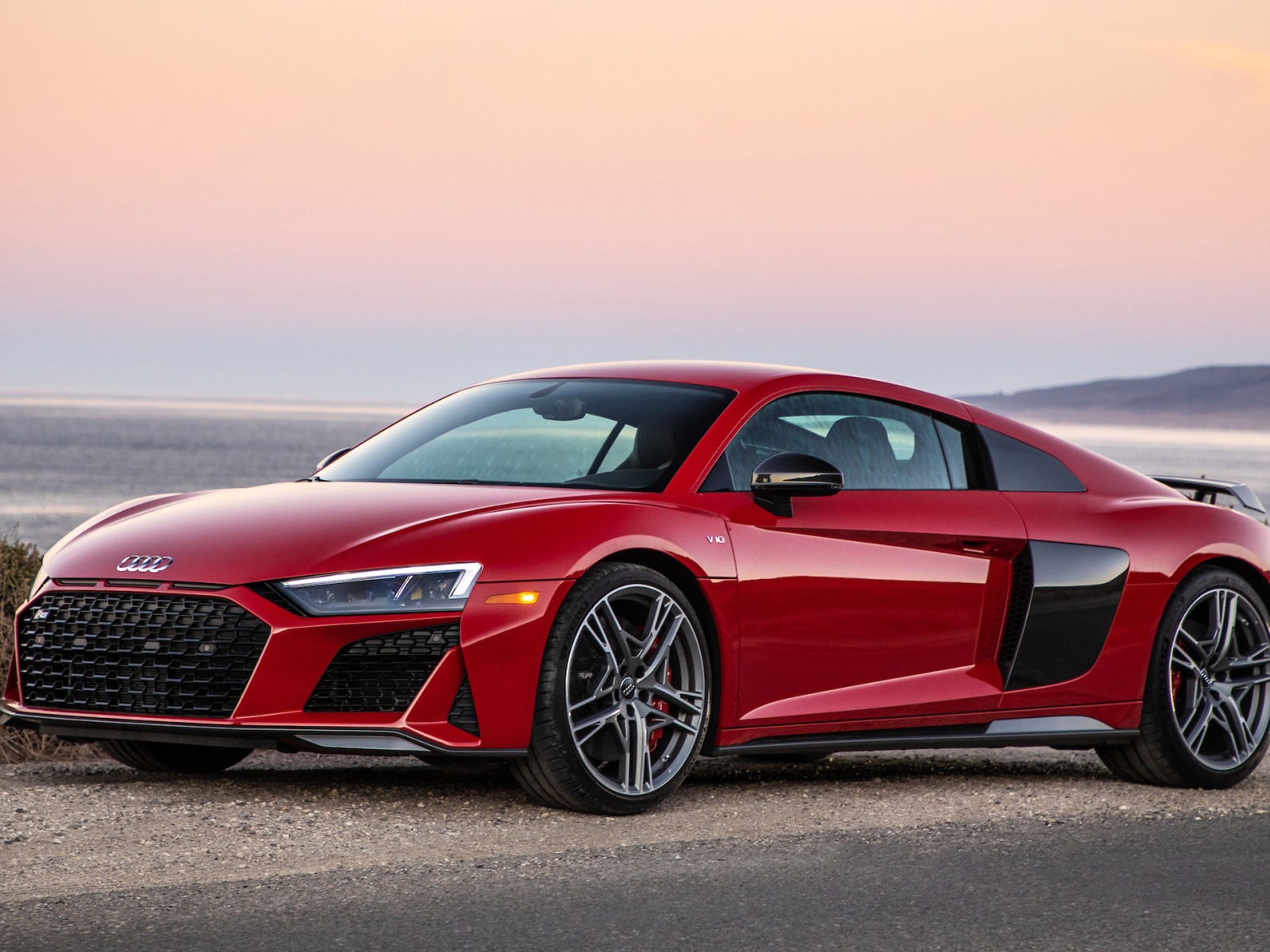 Красный спортивный автомобиль Audi R8 V10, 2020 года на фоне океана