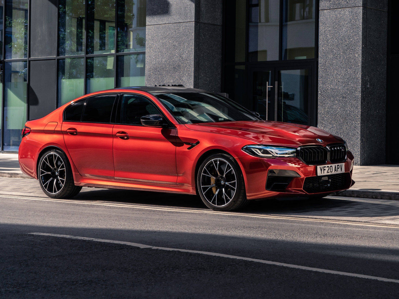 Красный автомобиль BMW M5 Competition 2020 года у дома