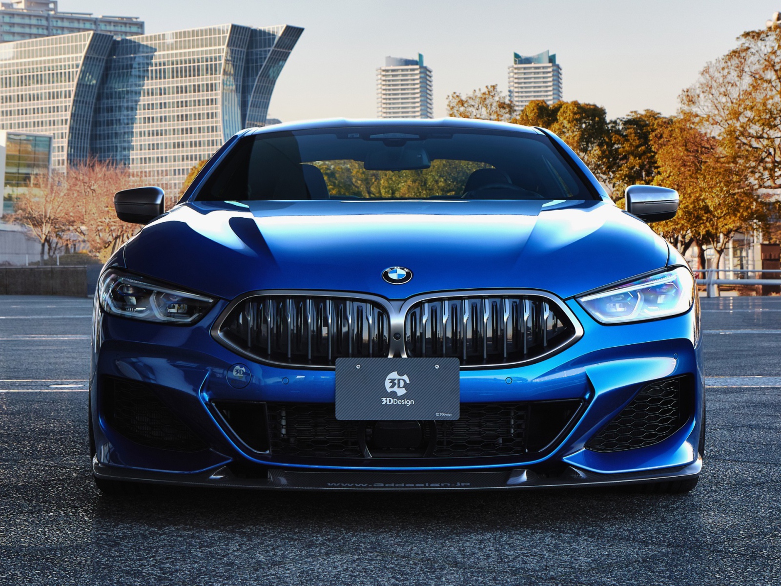 Синий автомобиль  BMW M850i XDrive Coupe 2020 года на фоне города 