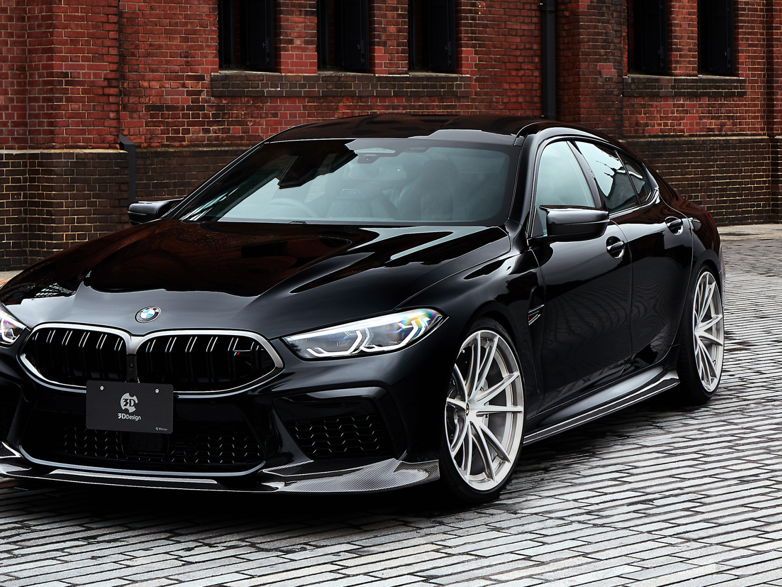 Дорогой черный автомобиль BMW M8 у стены