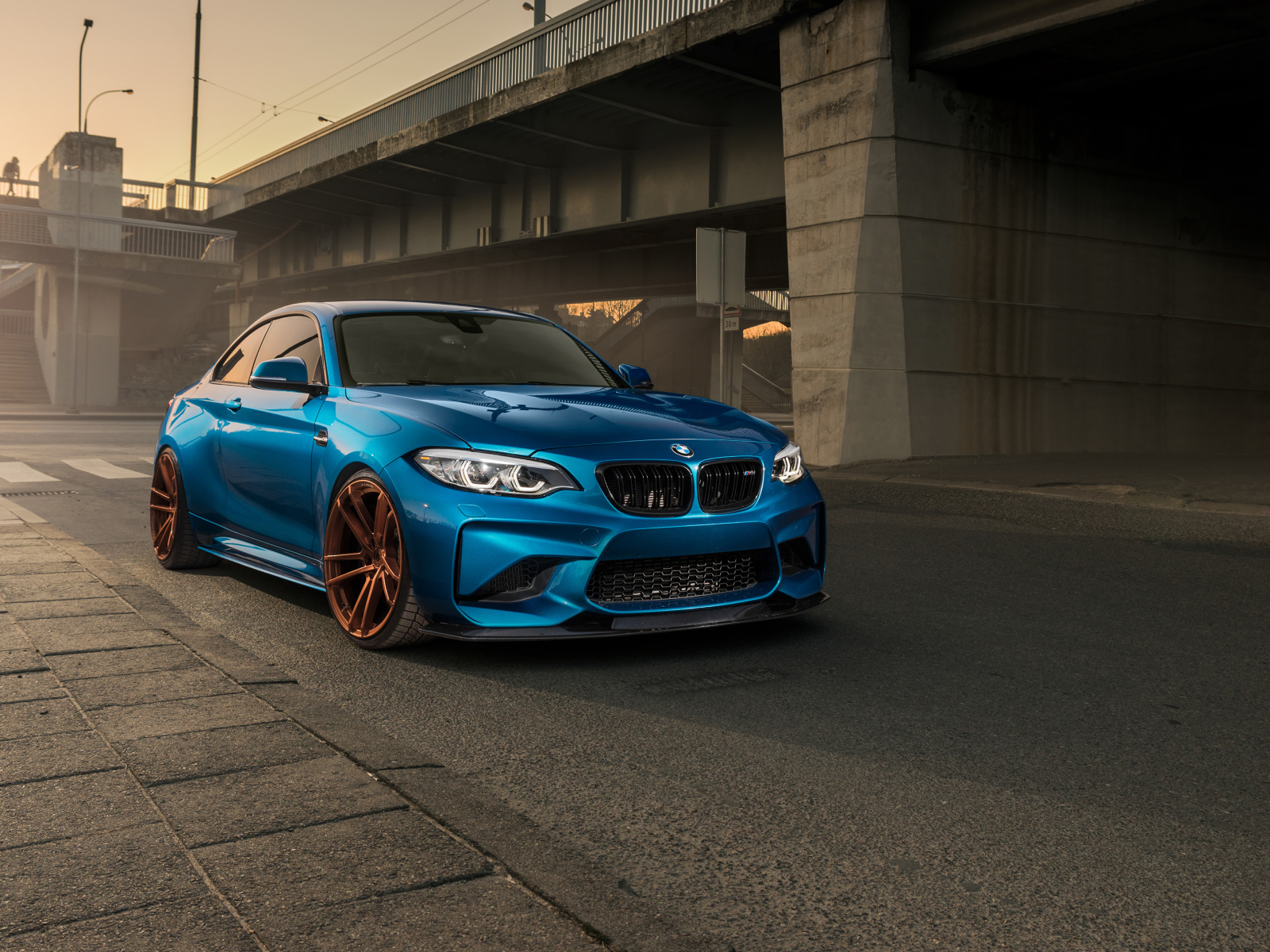 Синий автомобиль BMW M2 у моста 