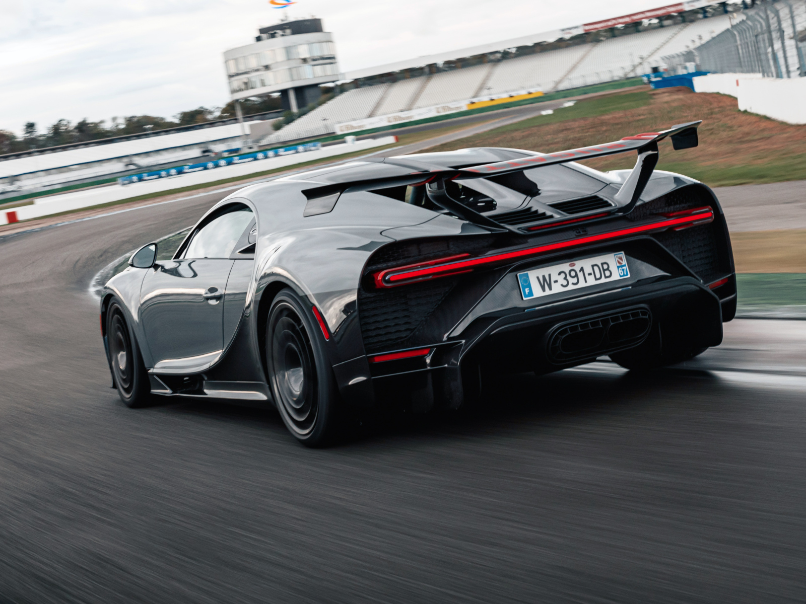 Черный быстрый автомобиль Bugatti Chiron Pur Sport 2020 года на стадионе