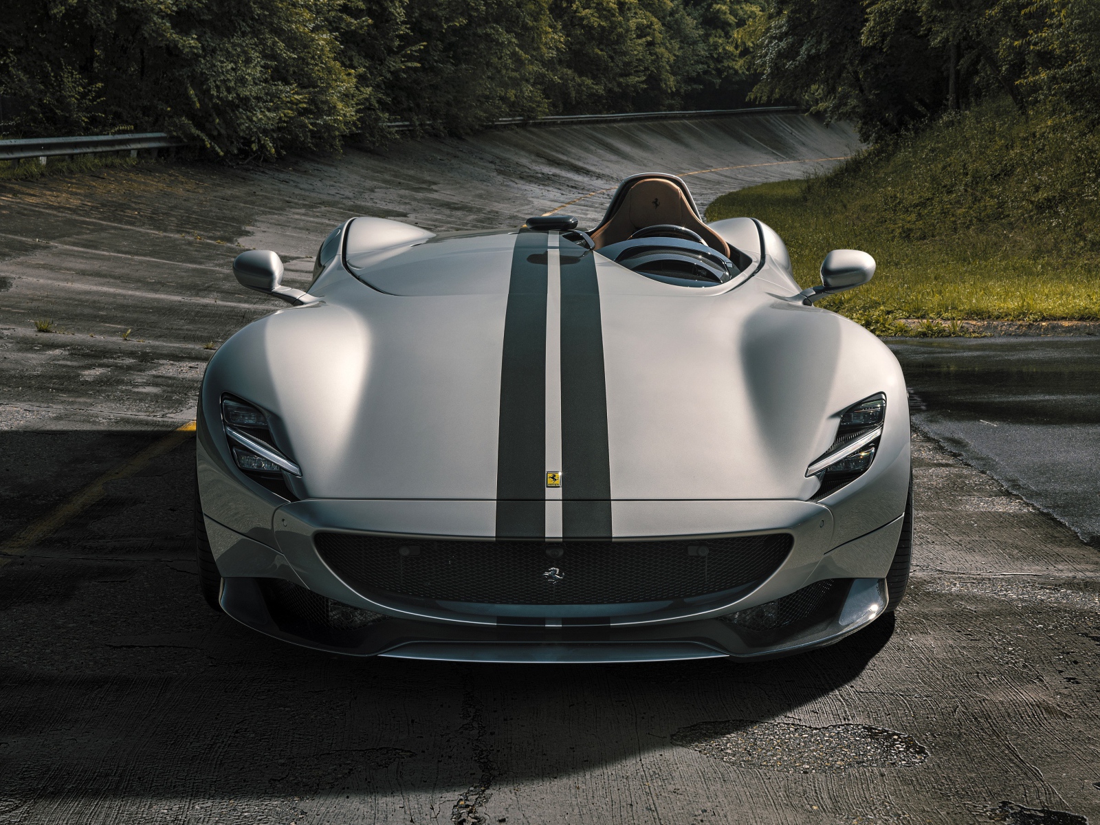 Серебристый кабриолет  Ferrari Monza SP1 2020 года на мокрой трассе 