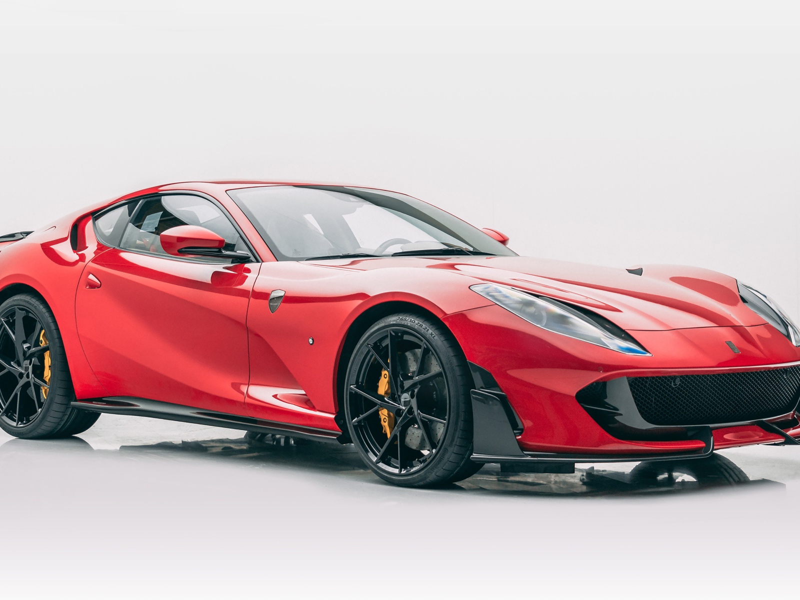 Красный быстрый автомобиль Mansory Ferrari 812 Superfast Soft Kit 2020 года на сером фоне