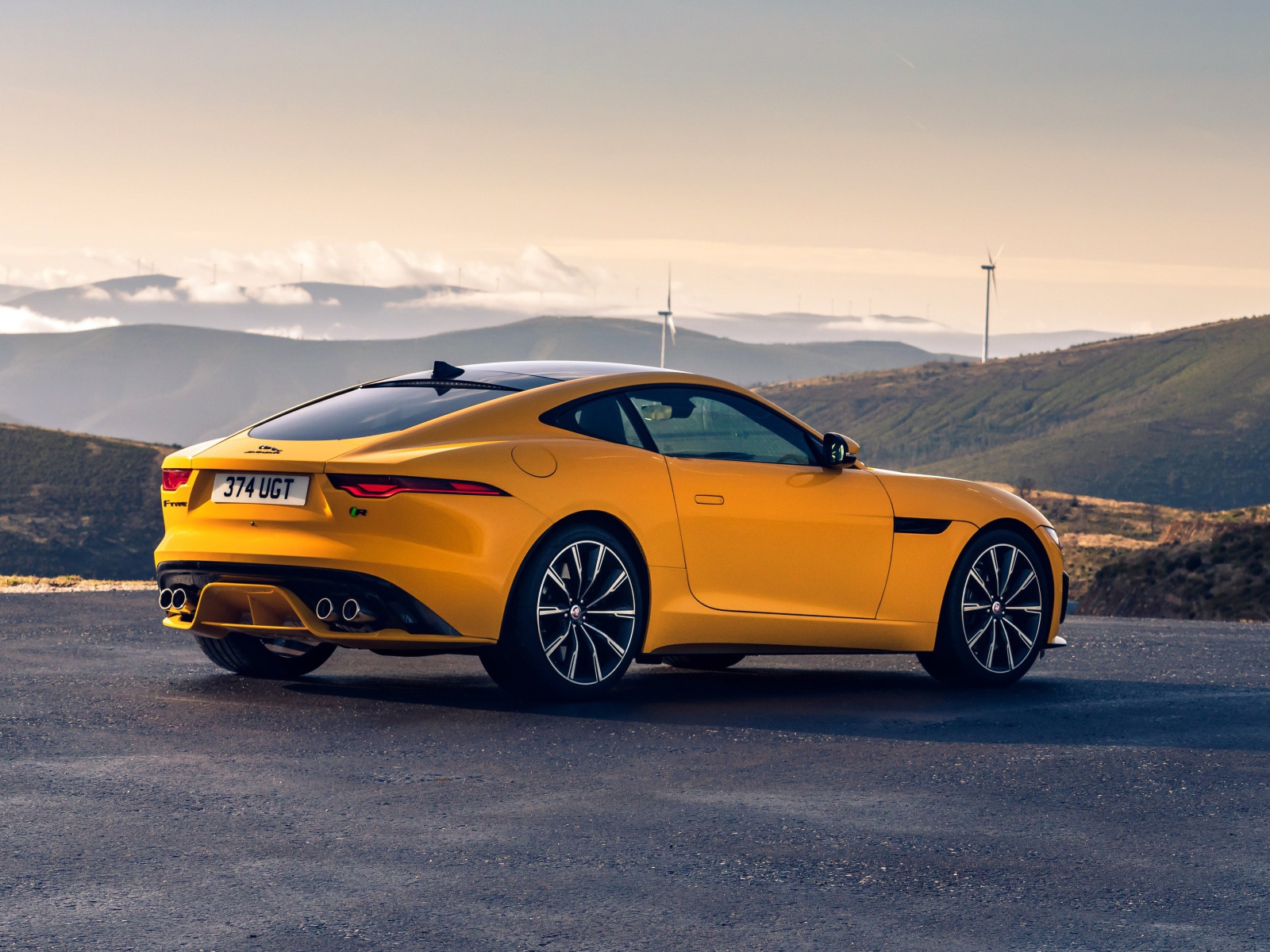 Желтый автомобиль Jaguar F-Type R Coupe 2020 года вид сзади