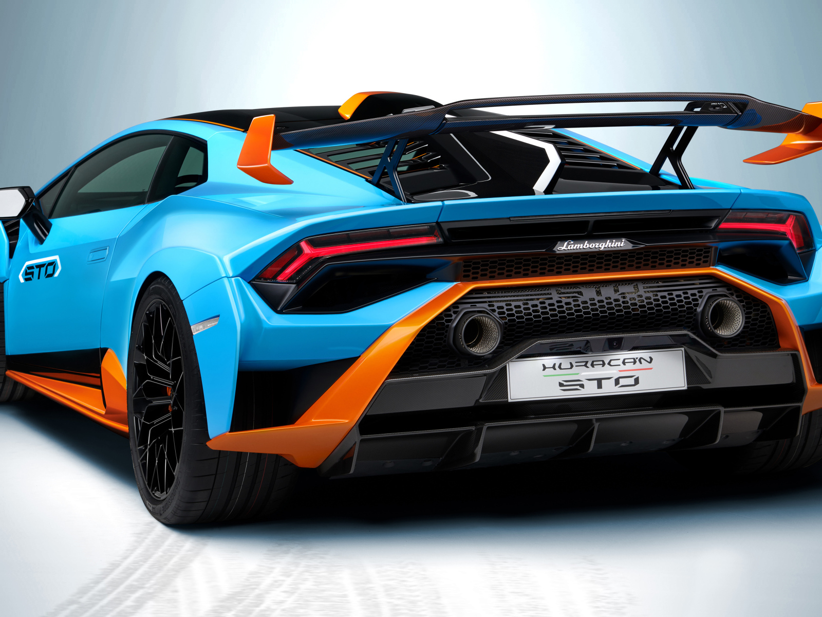 Автомобиль Lamborghini Huracán STO 2021 года вид сзади на сером фоне