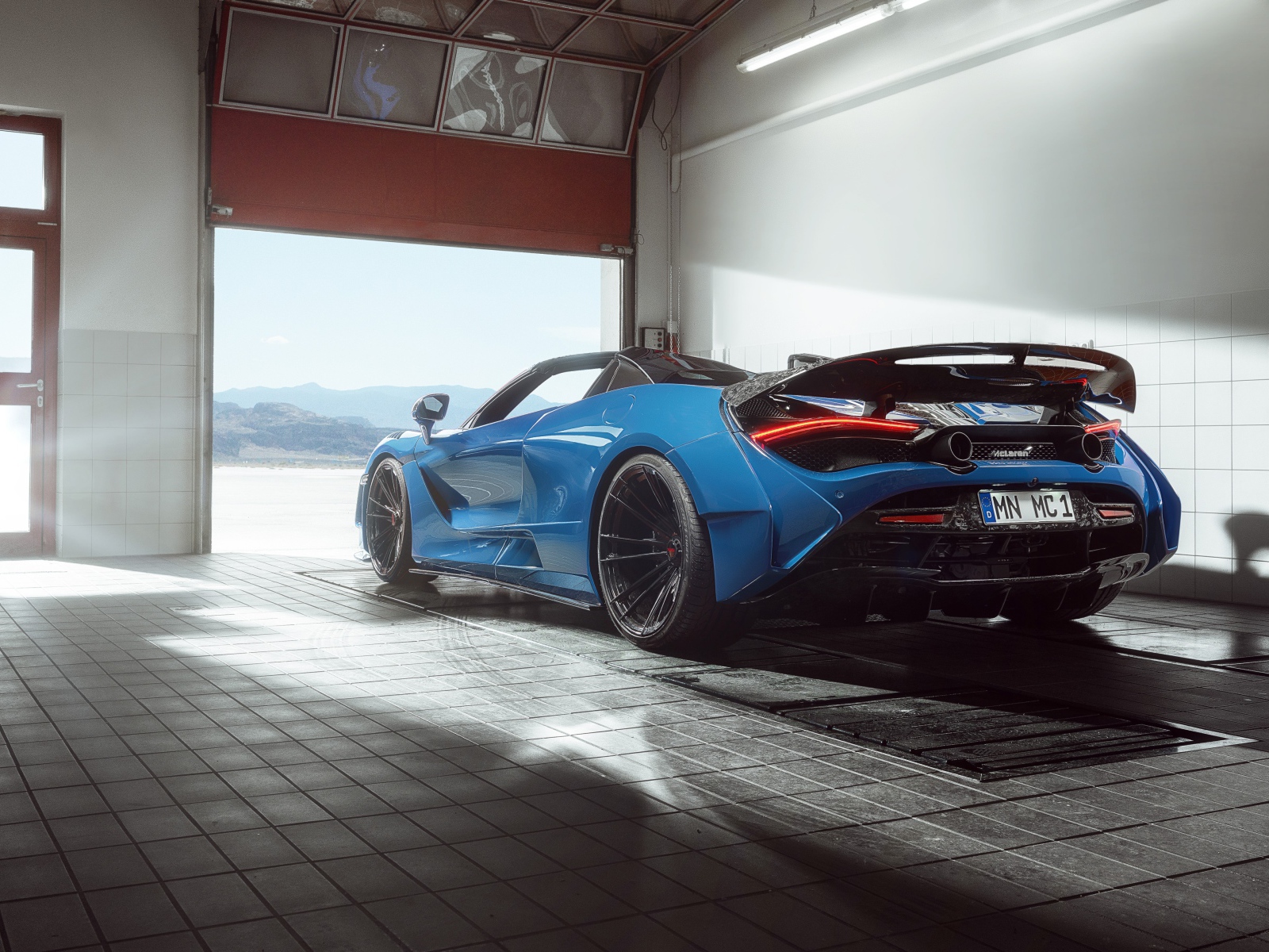 Спортивный автомобиль  McLaren 720S, 2020 года выезжает с гаража