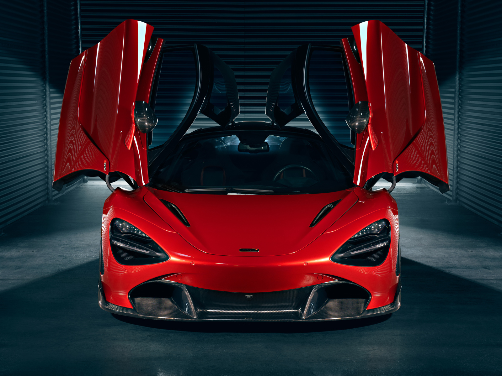 Красный автомобиль McLaren 720S с открытыми дверями в гараже