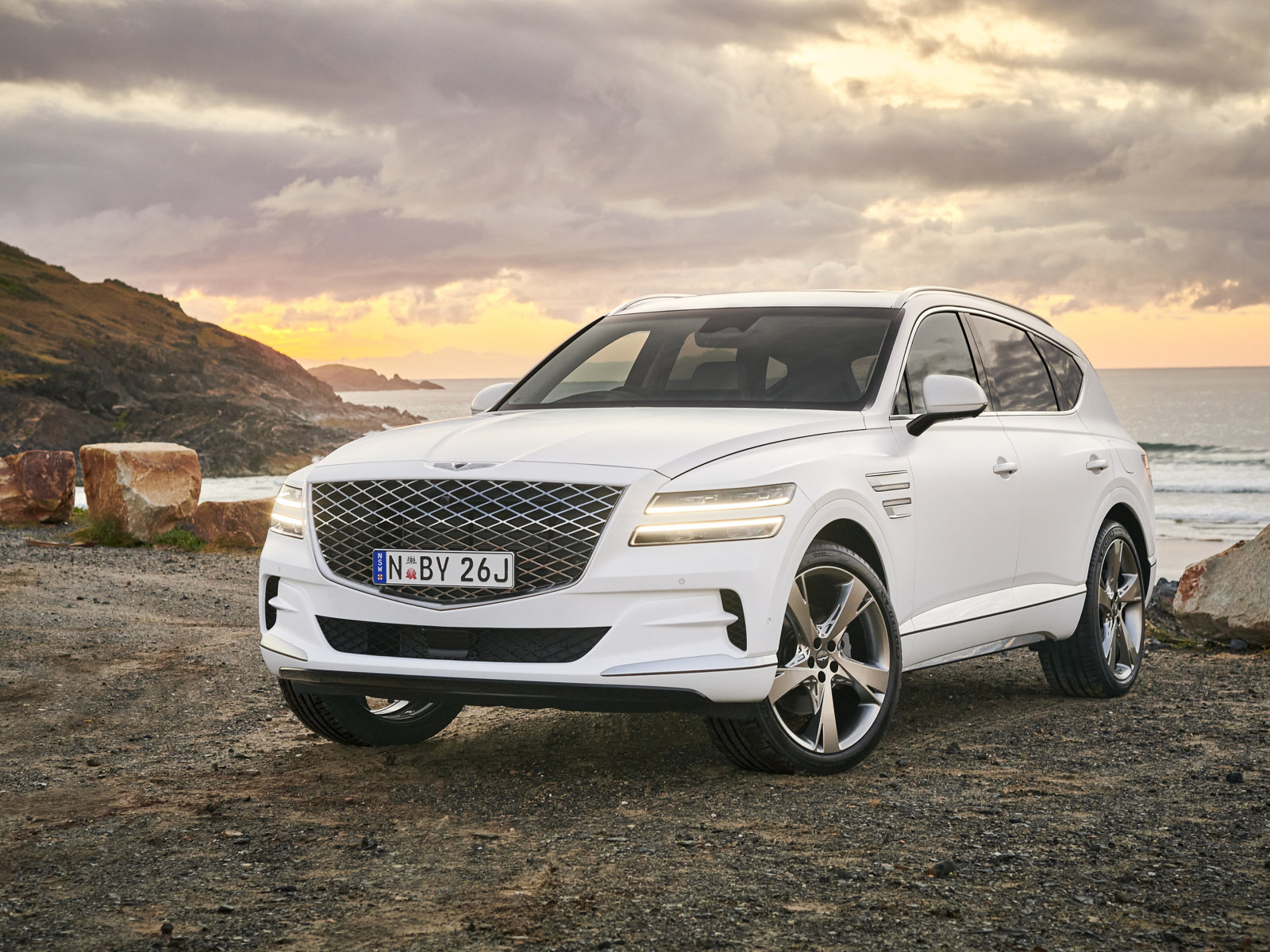 Белый автомобиль Genesis GV80 3.0D AWD 2020 года на фоне заката