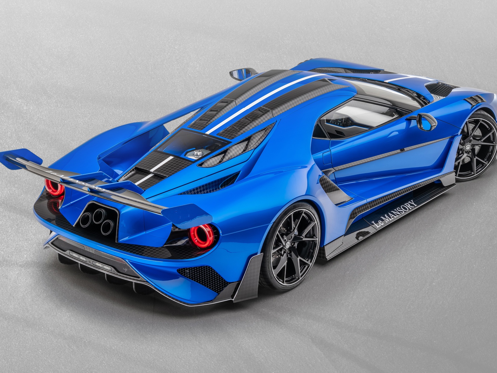 Синий автомобиль Mansory La MANSORY 2020 года на сером фоне вид сзади