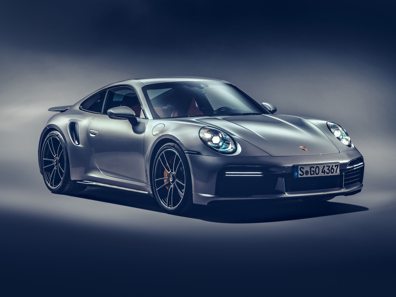Автомобиль Porsche 911 Turbo S 2020 года на сером фоне