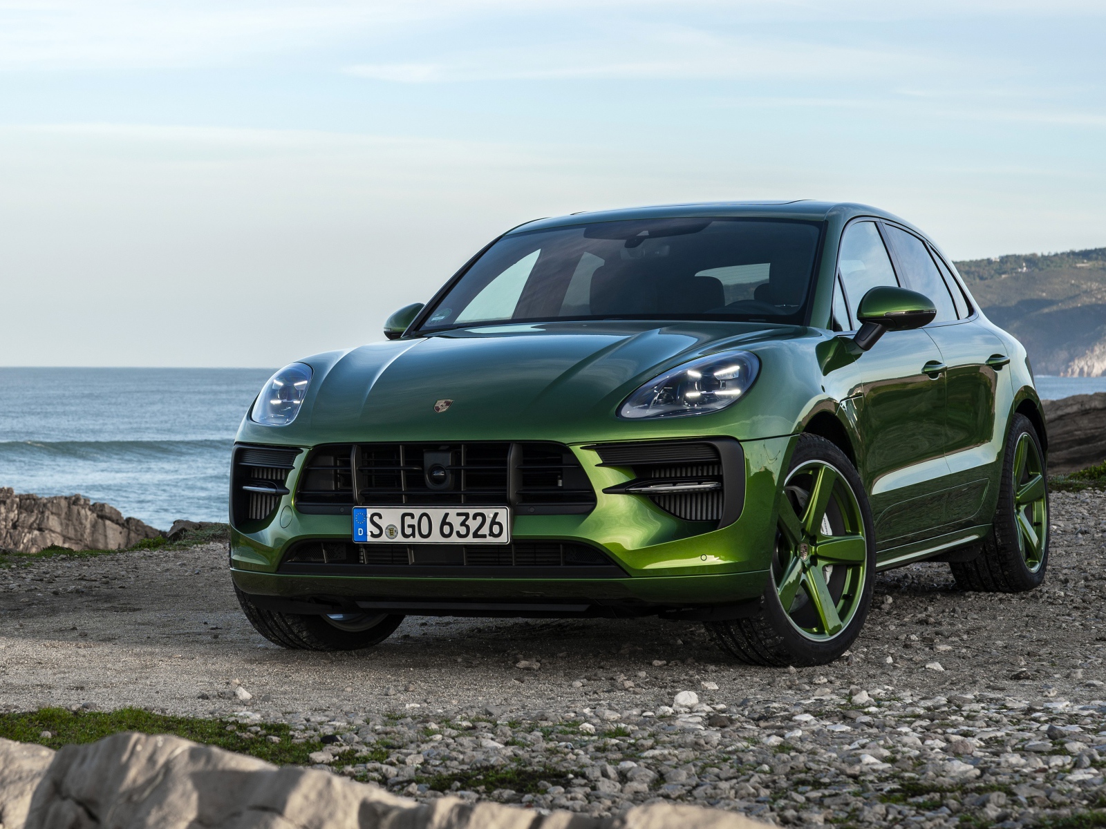 Зеленый автомобиль Porsche Macan GTS 2020 года на берегу моря