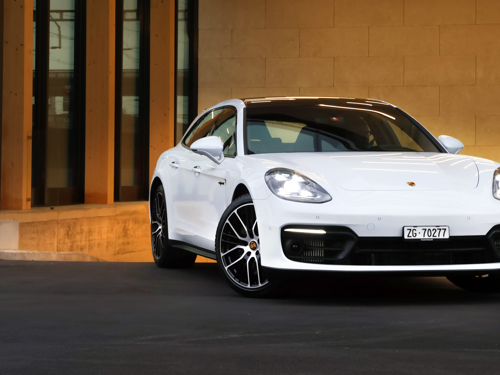 Белый автомобиль Porsche Panamera 4S E-Hybrid Sport Turismo 2020 года у дома
