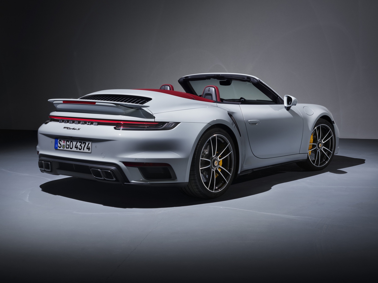 Белый автомобиль Porsche 911 Turbo S Cabriolet 2020 года вид сзади