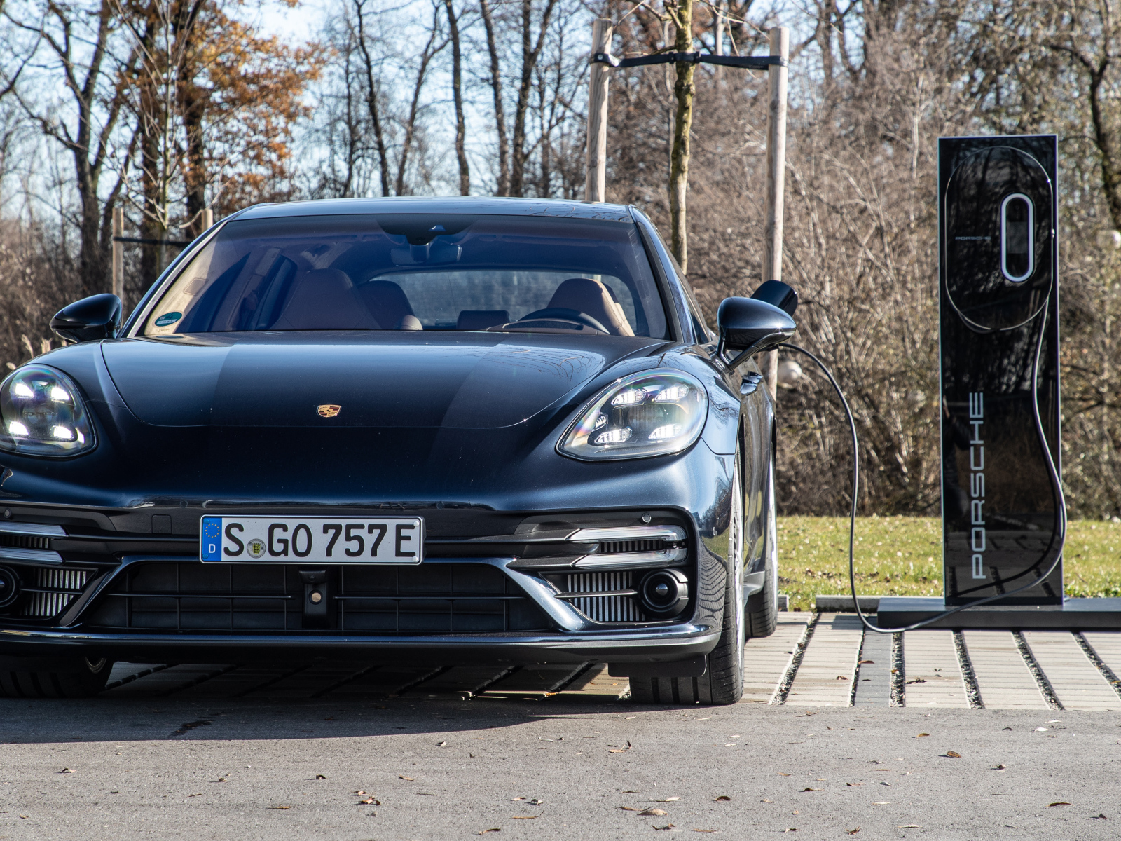Черный автомобиль Porsche Panamera Turbo S E-Hybrid Sport Turismo 2021 года на заправке