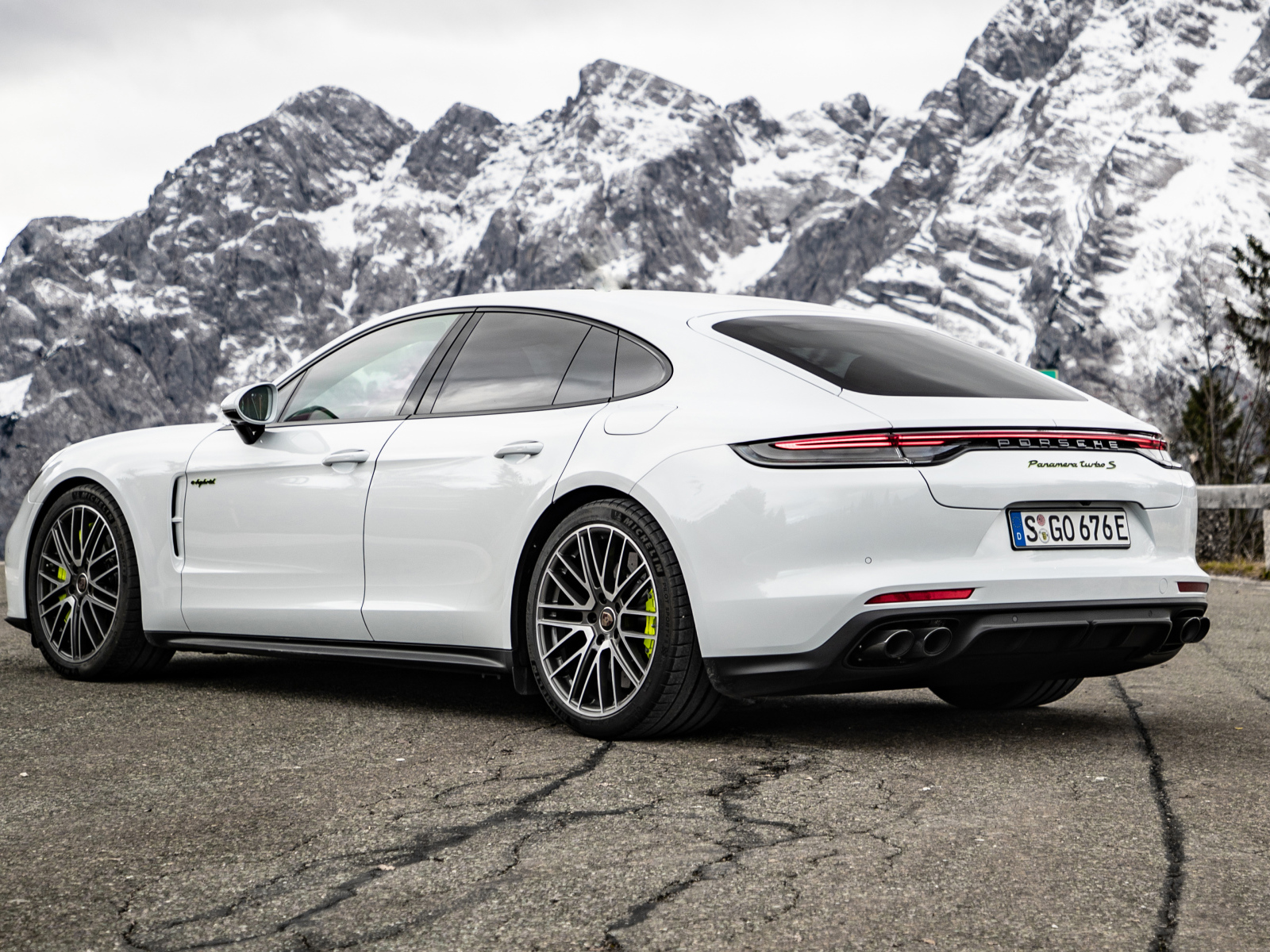 Белый автомобиль Porsche Panamera Turbo S E-Hybrid 2021 года на фоне гор