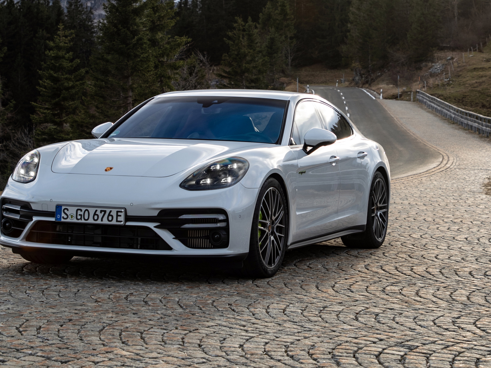 Белый автомобиль Porsche Panamera Turbo S E-Hybrid 2021 года на дороге