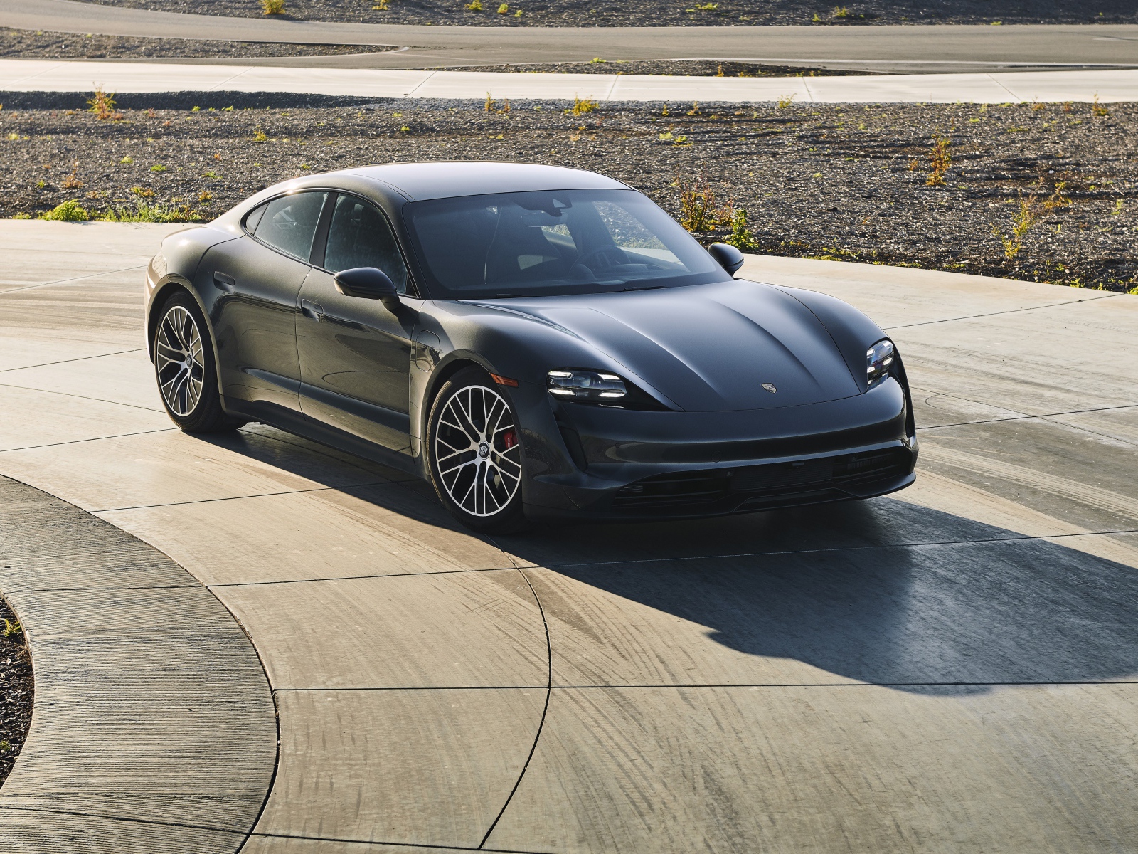 Черный автомобиль Porsche Taycan, 2020 года на дороге 