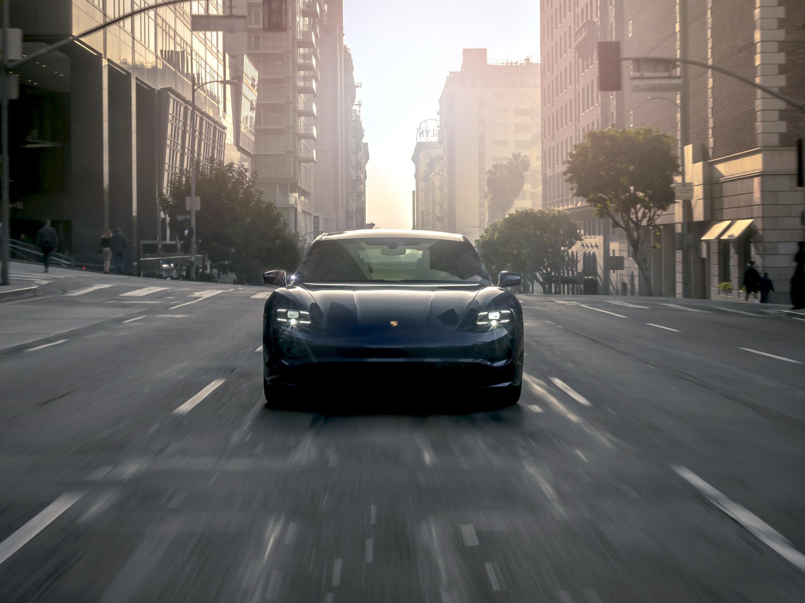 Черный стильный автомобиль  Porsche Taycan Turbo, 2020 года на дороге в городе