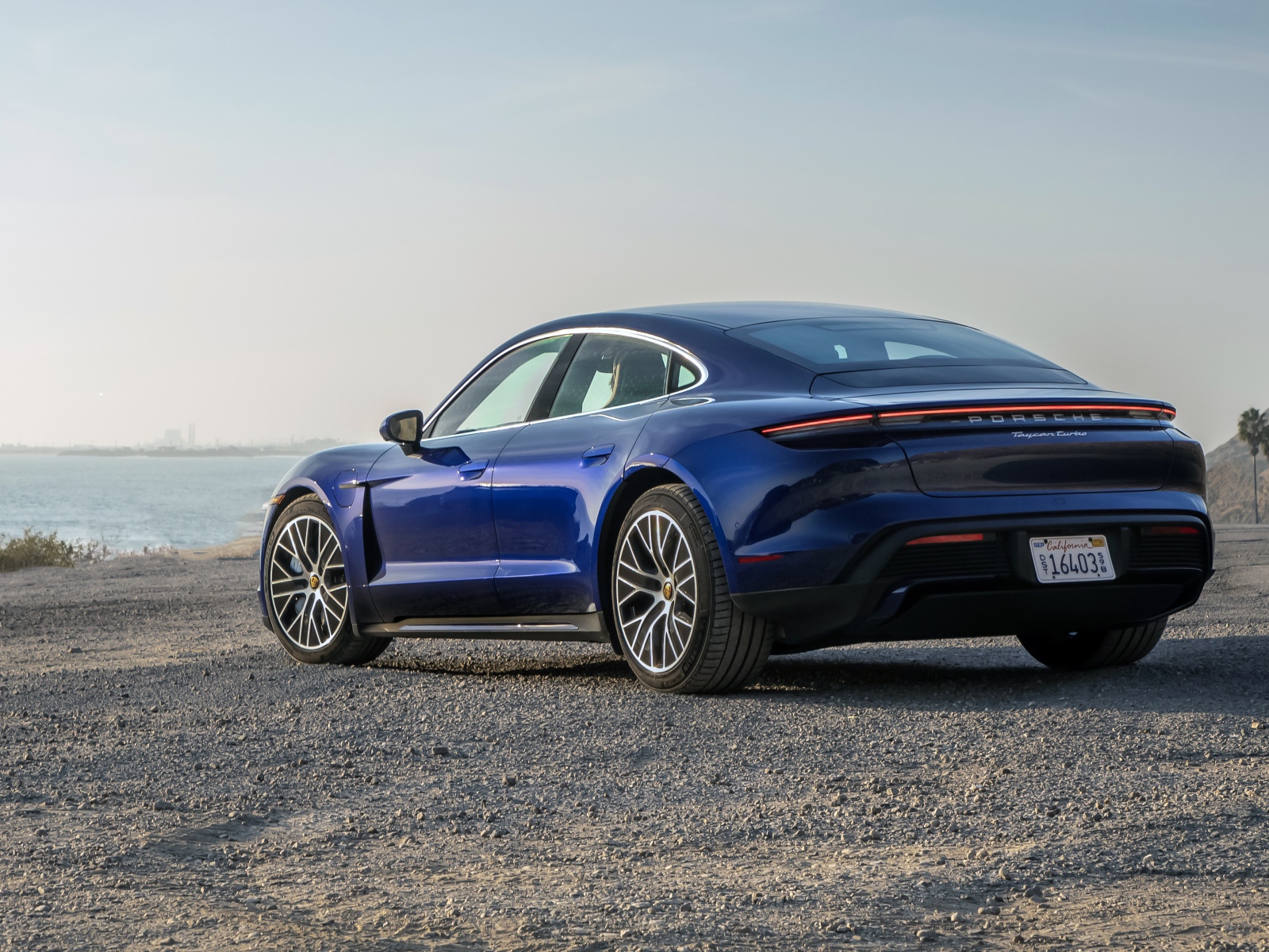 Синий автомобиль  Porsche Taycan, 2020 года вид сзади