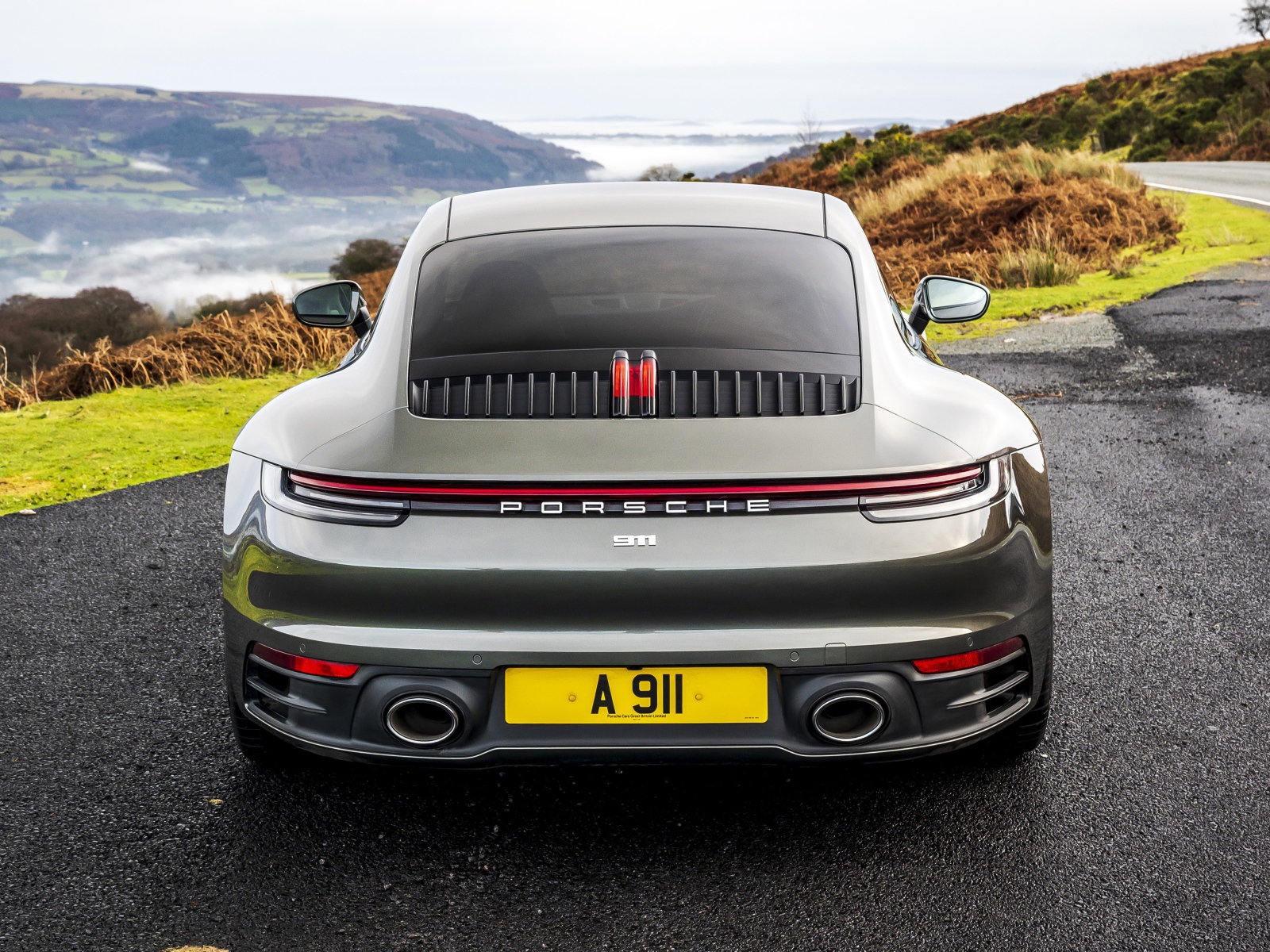 Автомобиль Porsche 911 Carrera на дороге у обрыва