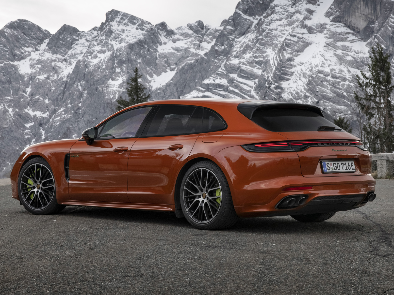 Красный автомобиль Porsche Panamera 4 E-Hybrid 2021 года на фоне гор