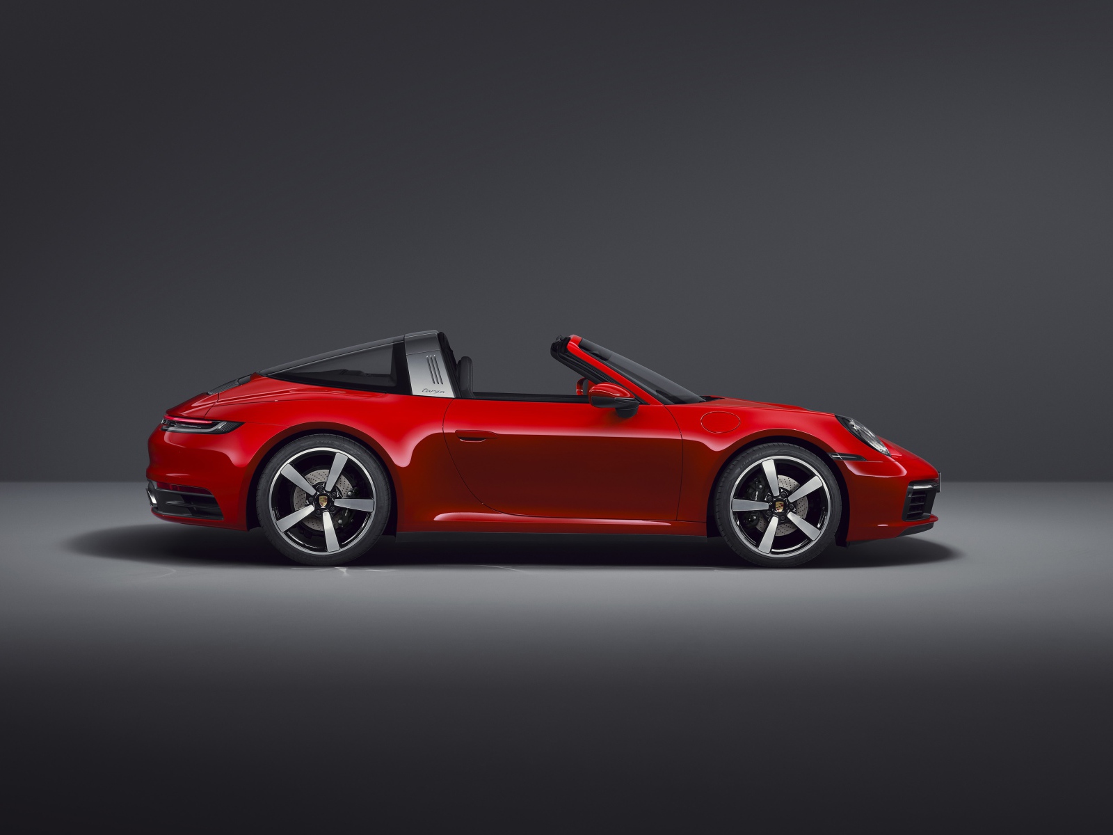 Красный кабриолет Porsche 911 Targa 4 2020 года на сером фоне