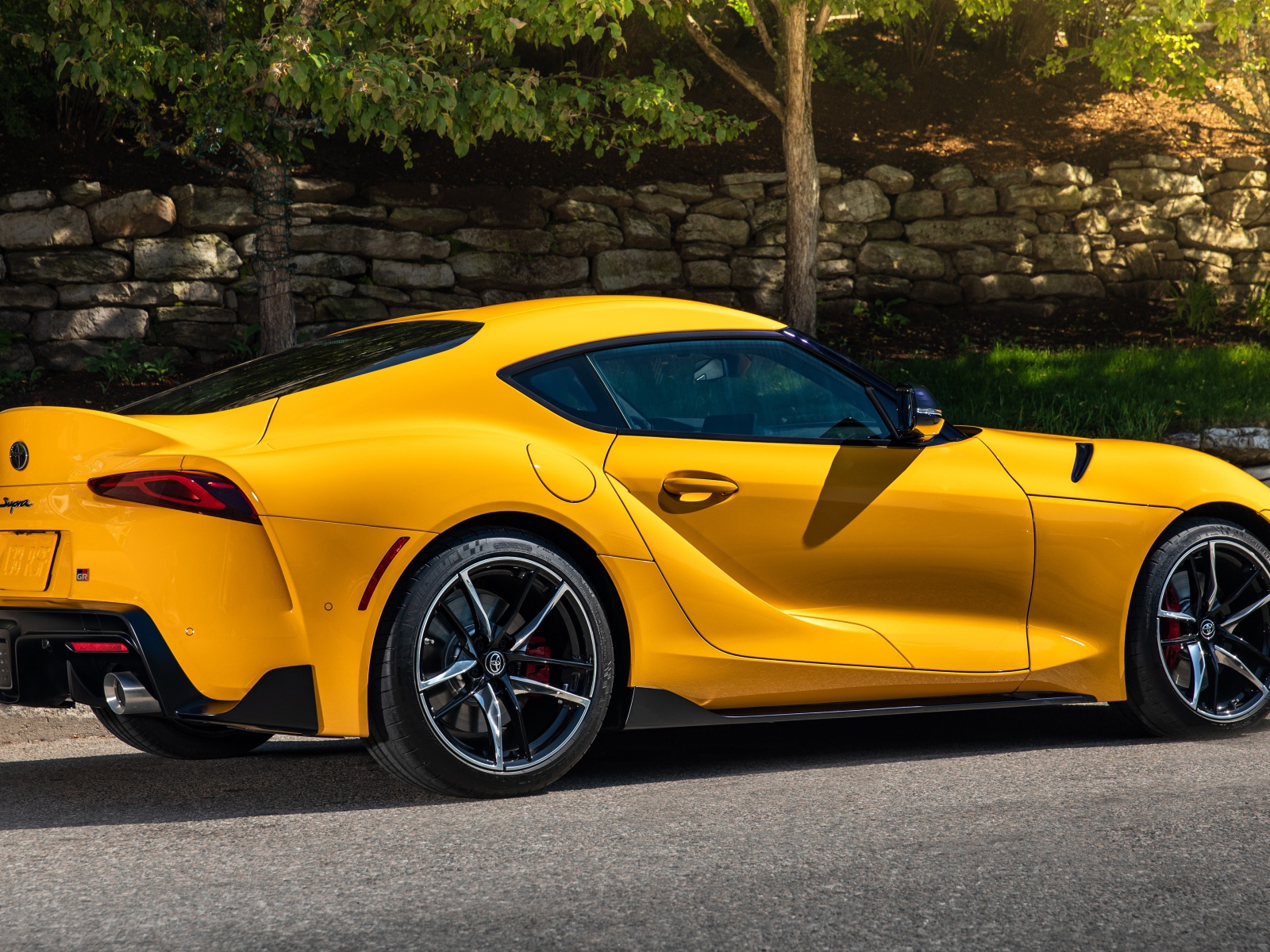 Желтый автомобиль Toyota GR Supra 2, 2021 года вид сбоку 