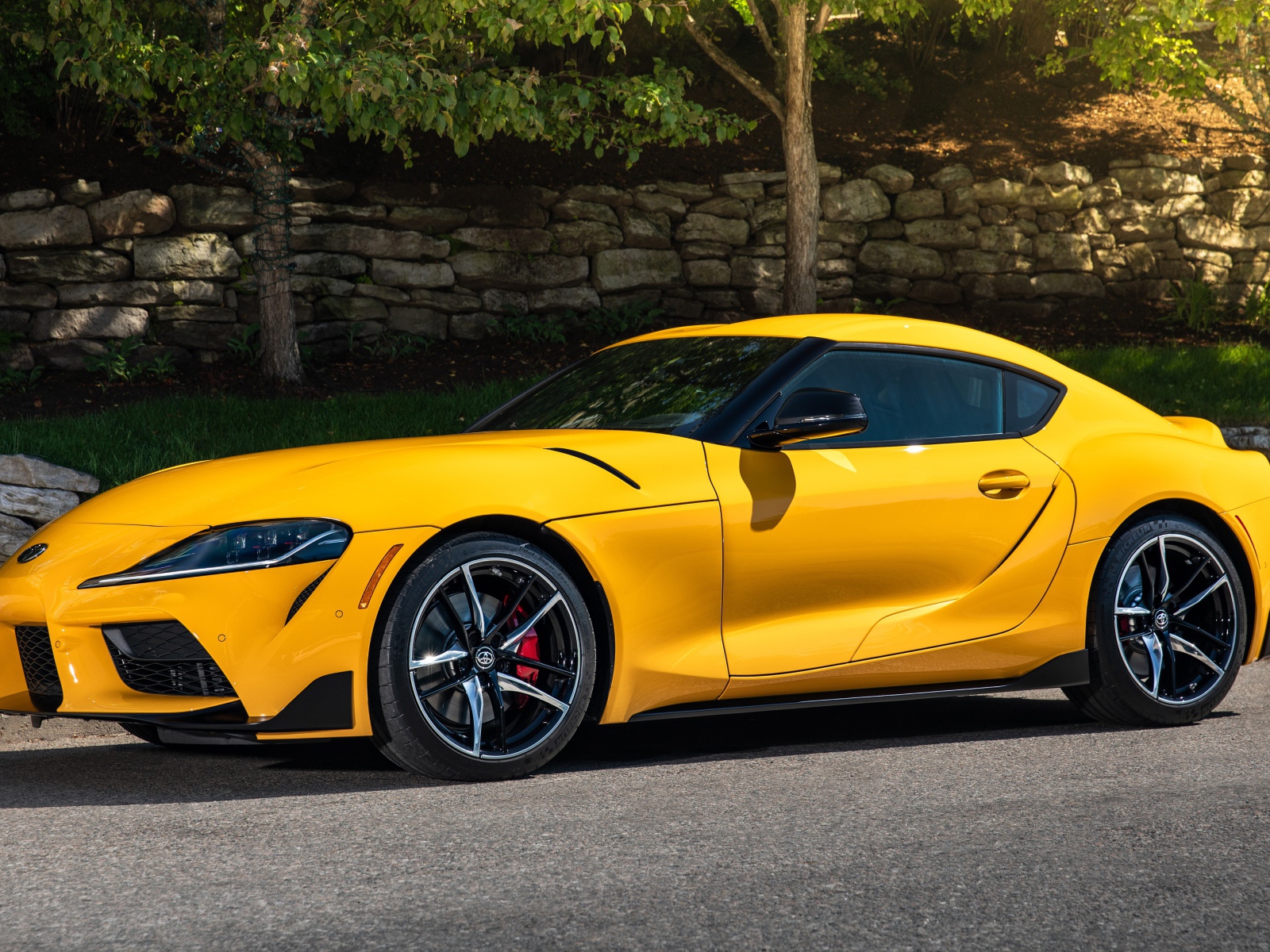 Желтый автомобиль Toyota GR Supra,ю 2021 года у стены