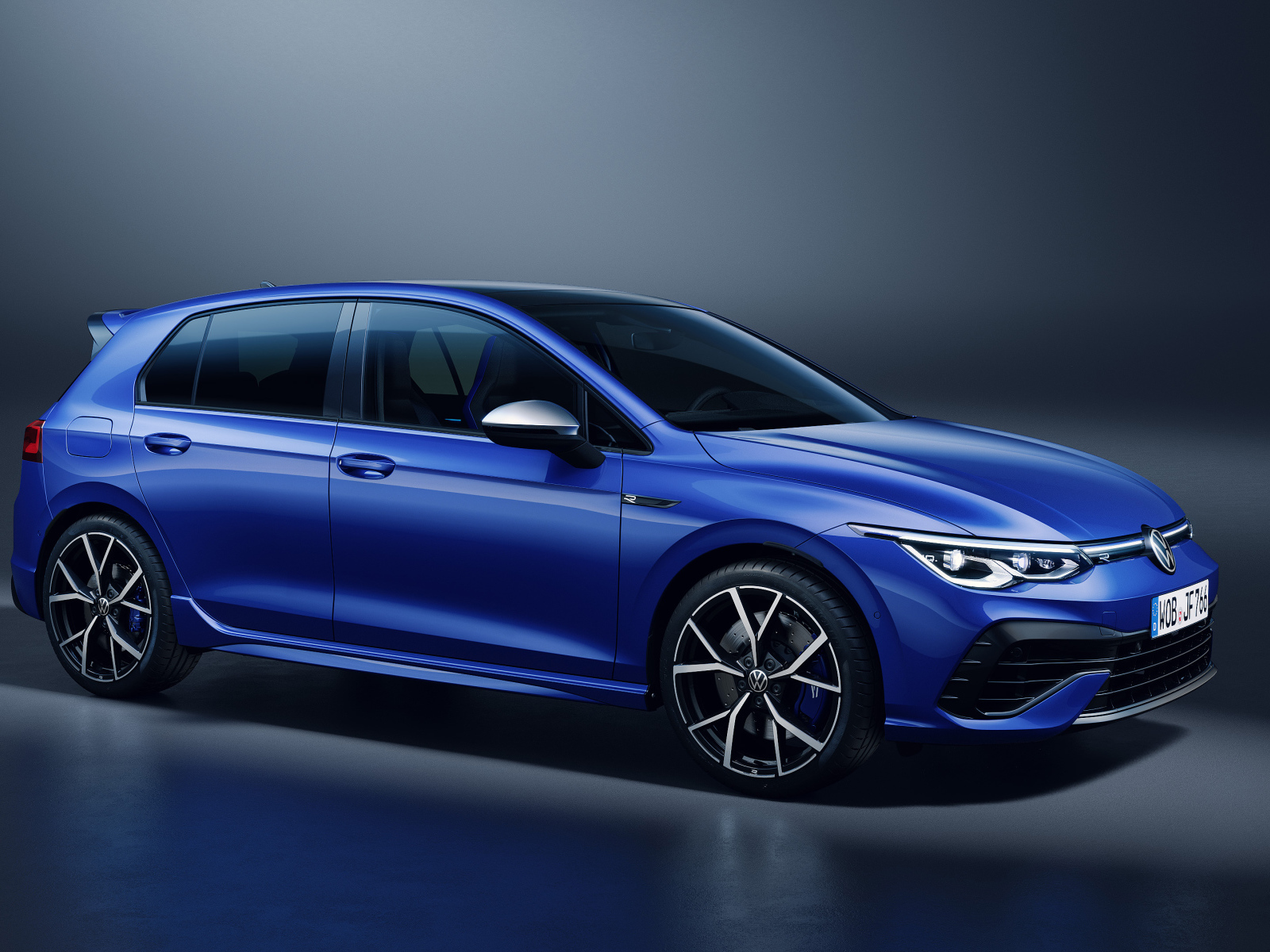 Синий автомобиль Volkswagen Golf R 2020 года на сером фоне