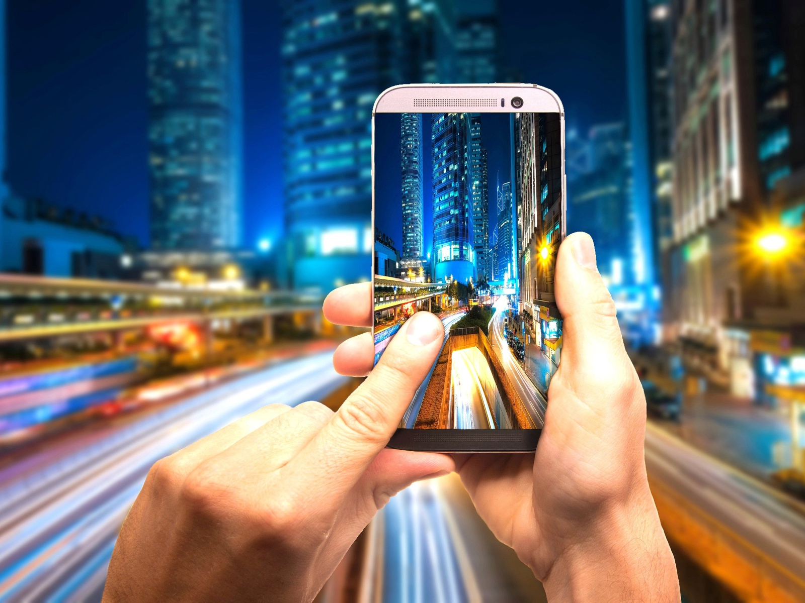 Мужчина делает фото ночного города на смартфон 