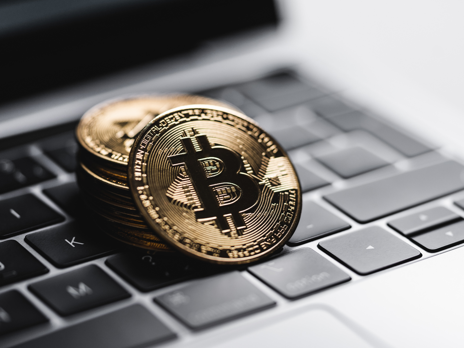 Bitcoin coins lie on a laptop keyboard