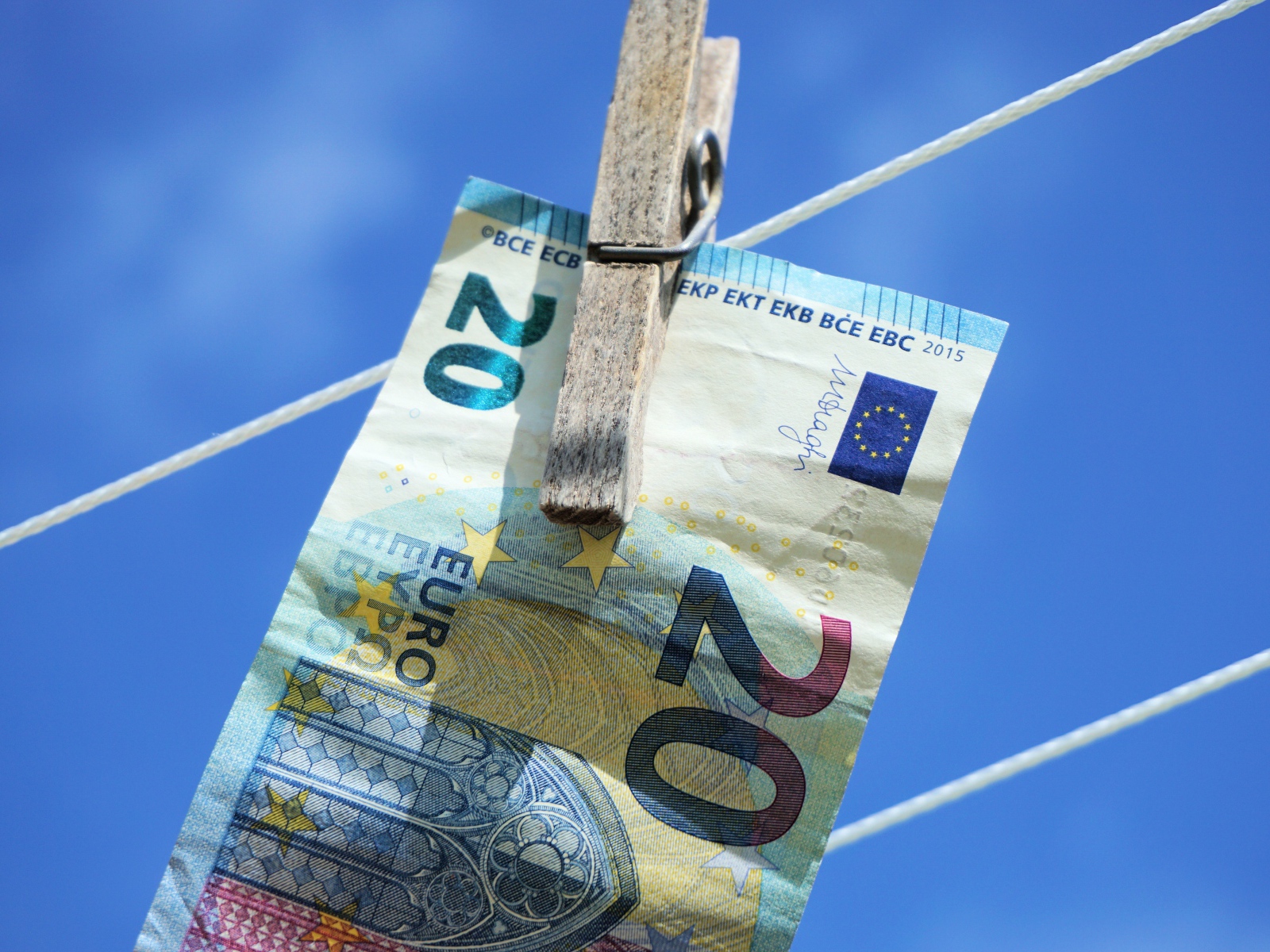 Купюра двадцать евро висит на веревке 
