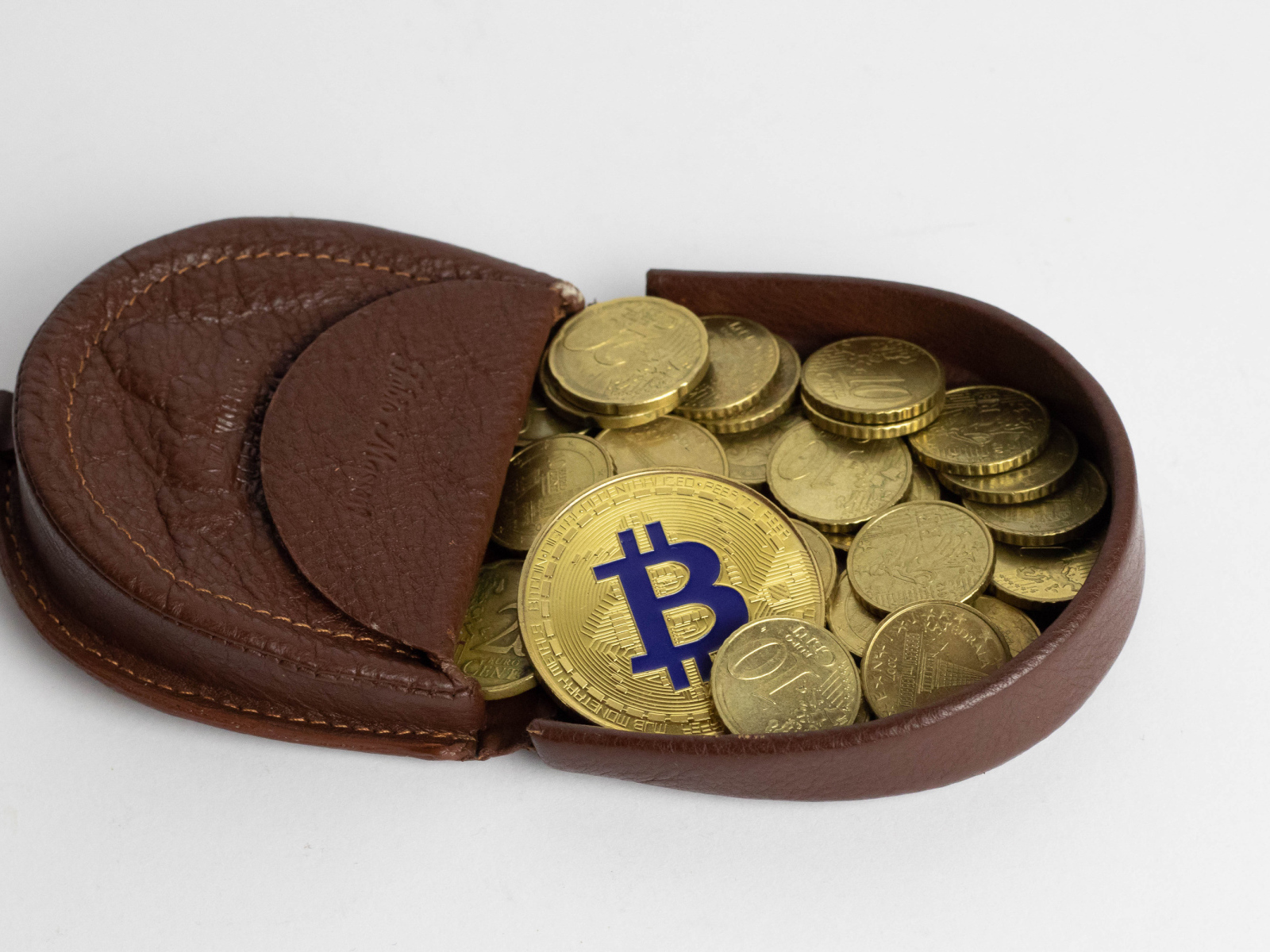 Кожаный кошелек с монетами на сером фоне