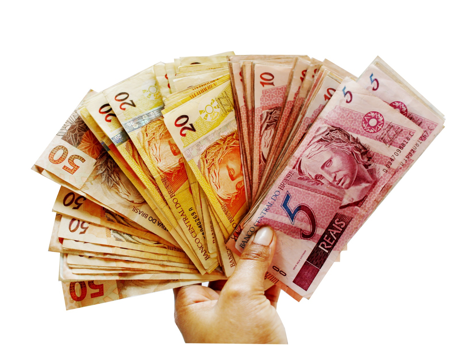 Много купюр бразильского реала в руке на белом фоне 