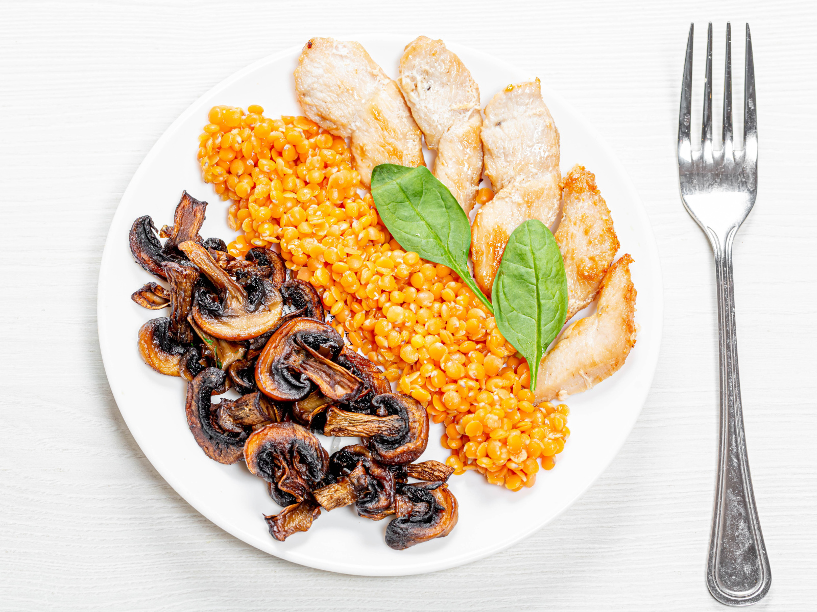 Шампиньоны на тарелке с чечевицей и курицей